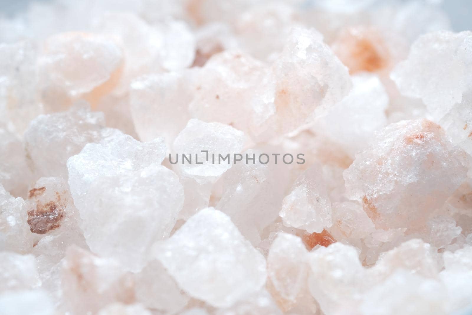 close up of pink rock salt in a bowl on table .