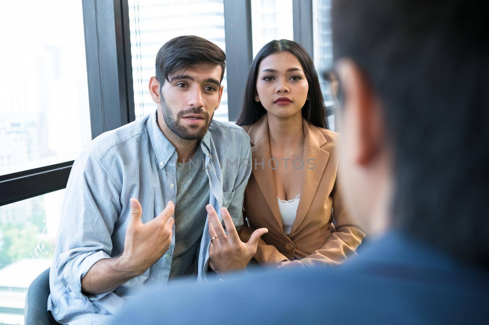 Psychotherapist inquiring about symptoms occurring within mind from patients with mental health problems in hospital. Group psychotherapy for support and helping worried man to change negative mindset