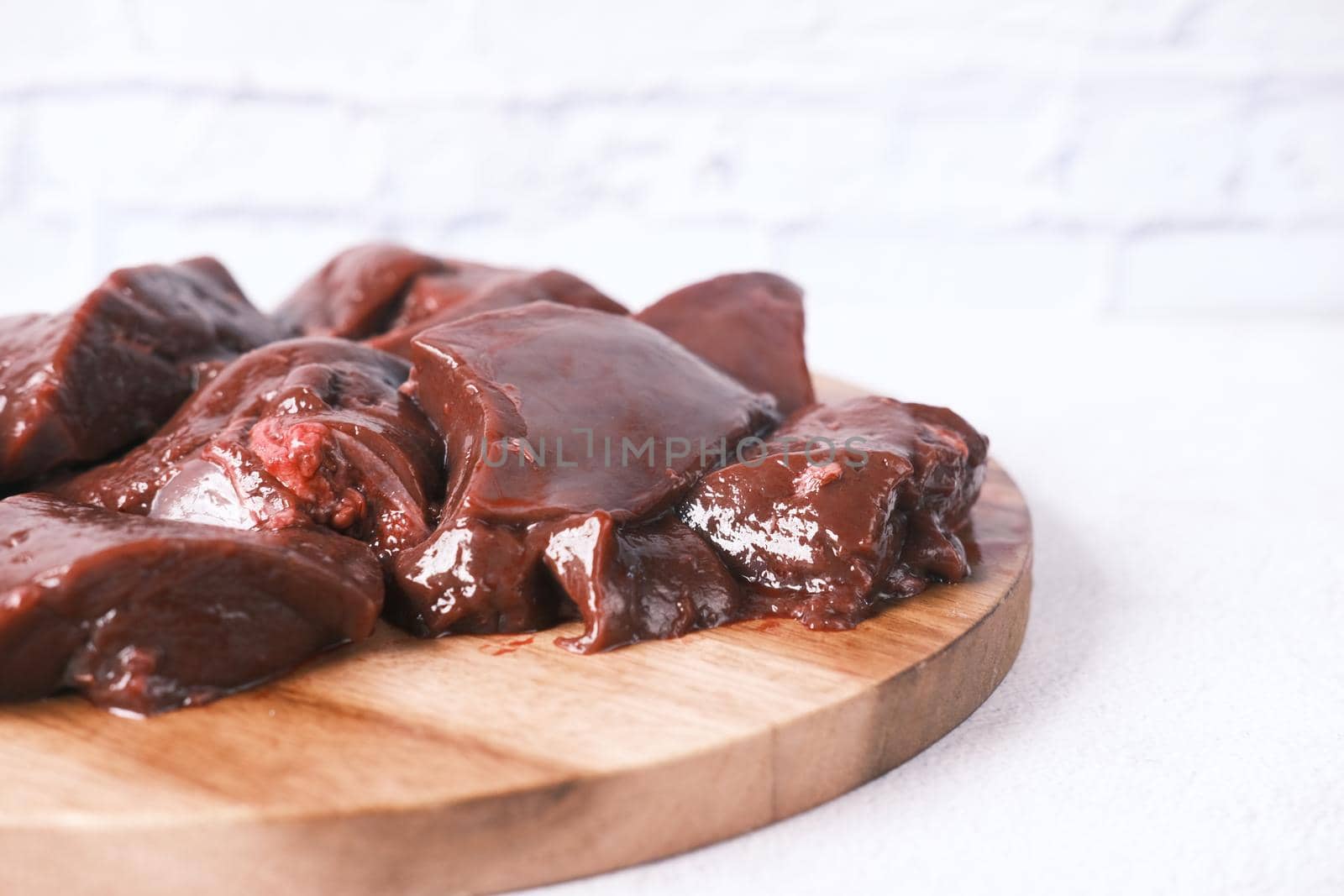 Raw liver on a chopping board on table