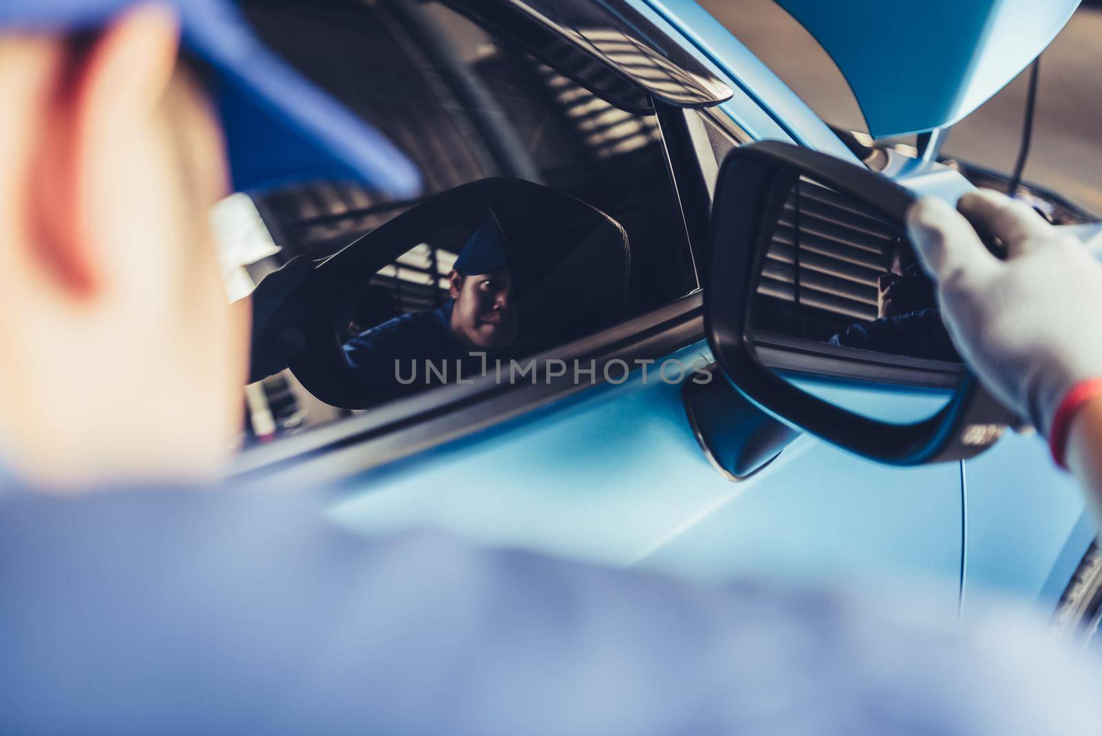 Mechanic car technician is looking at the rear view mirror for checking to maintenance vehicle by customer claim order in auto repair shop garage. Repair service. People occupation and business job