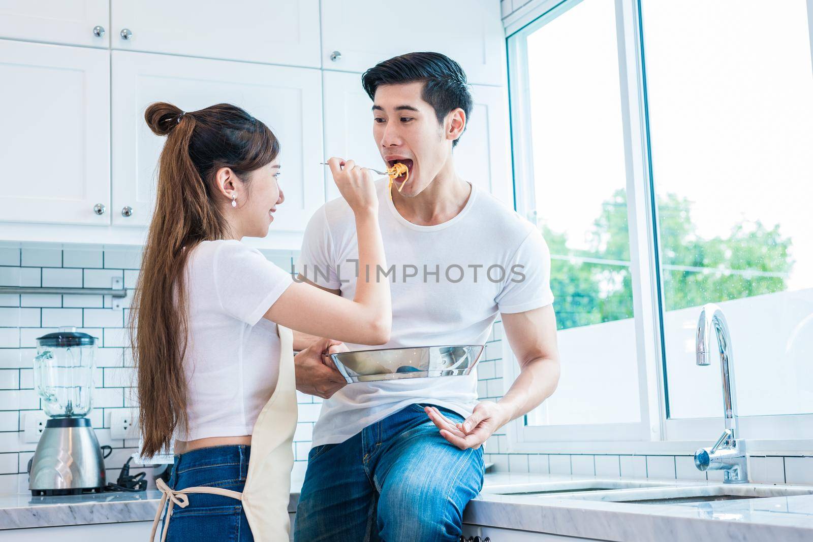 Woman feeding food to man as Lovers or couples in kitchen room. Honeymoon and wedding concept. Cooking theme 