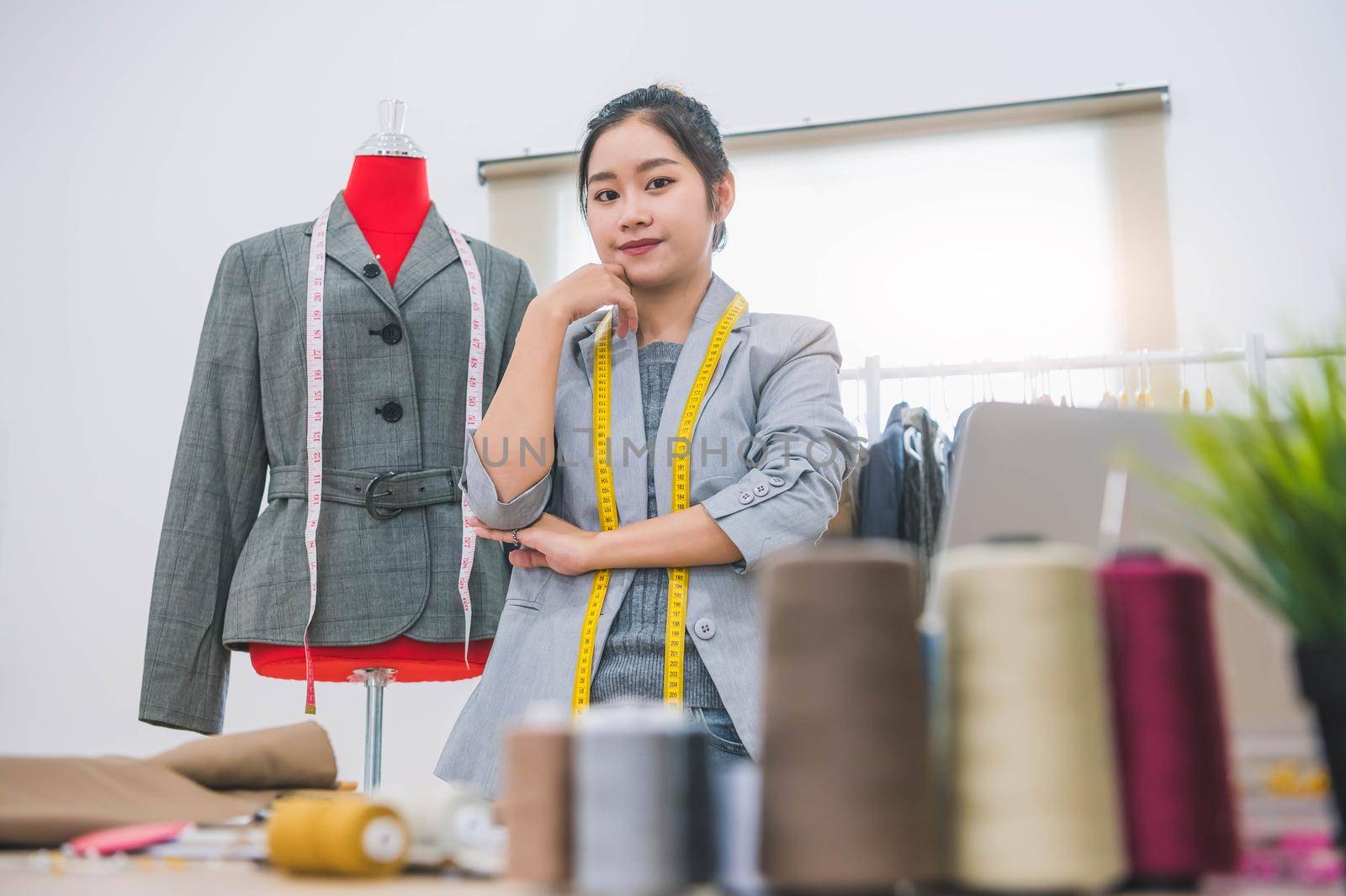 Fashion designer stylist in business owner workshop. Tailor and sewing concept. Portrait of happy casual trendy fashion designer businesswoman in studio looking camera. Business job and occupation