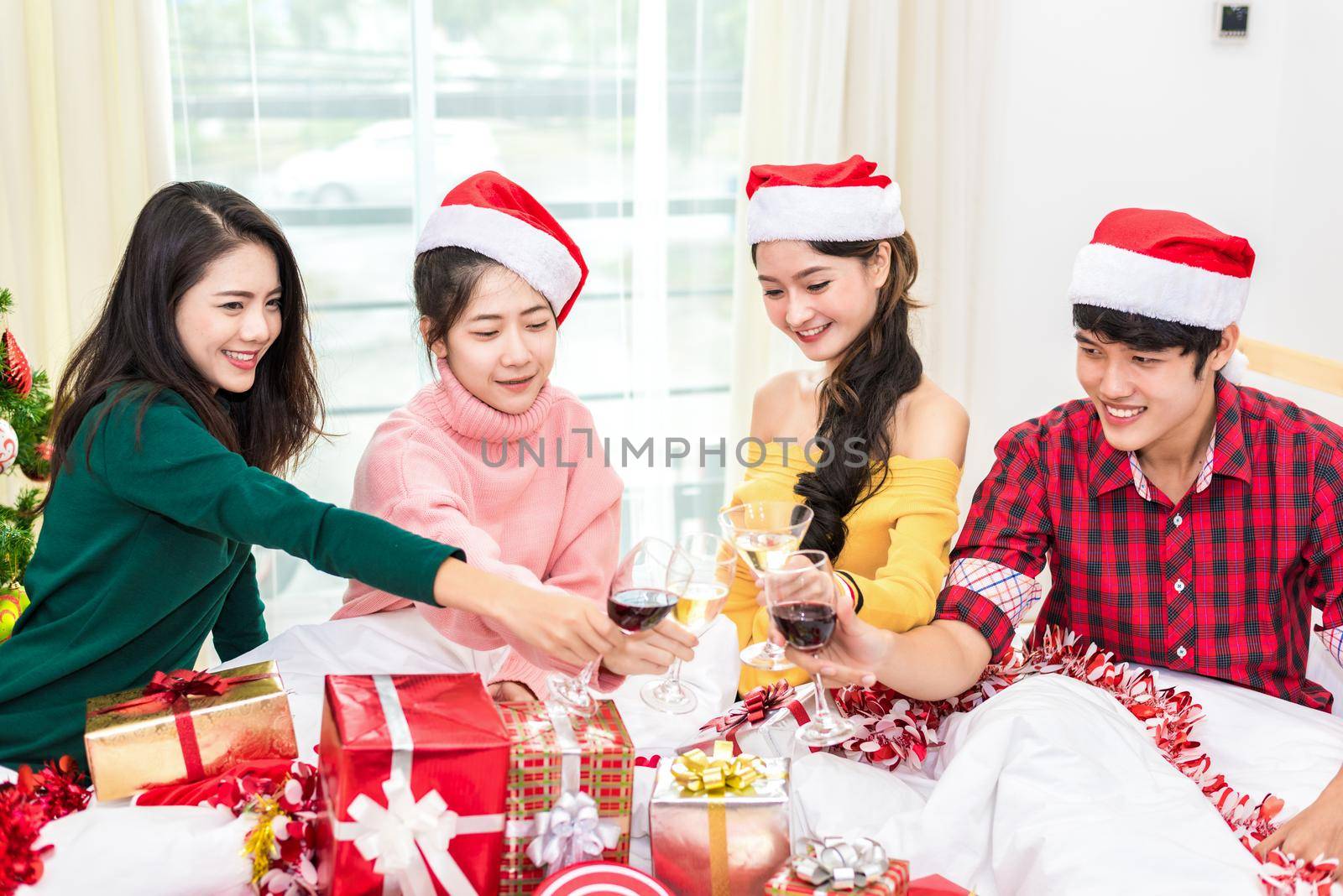 Group of young Asian people celebrating New year party in home with wine drinking glasses. New year and Christmas party concept. Happiness and Friendship concept. Relation and Funny together theme.