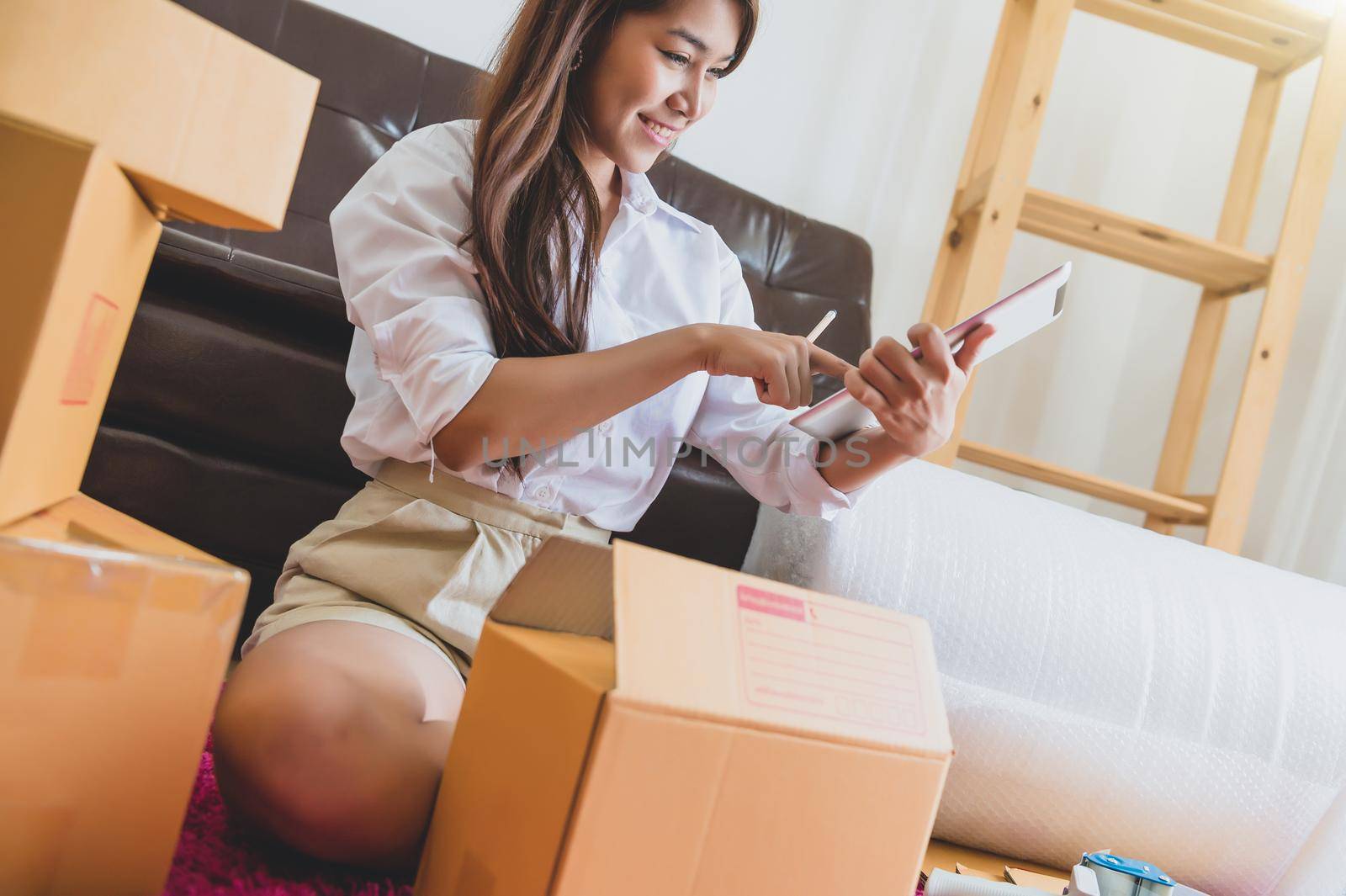Asian business woman startup small business entrepreneur SME distribution warehouse with parcel mail box. small owner home office. Online marketing and product packaging and delivery service concept