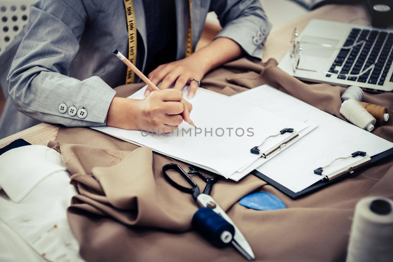 Closeup of attractive female fashion designer hand working in home office workshop. Stylish fashionista woman creating new cloth design collection. Tailoring and sewing People lifestyle and occupation