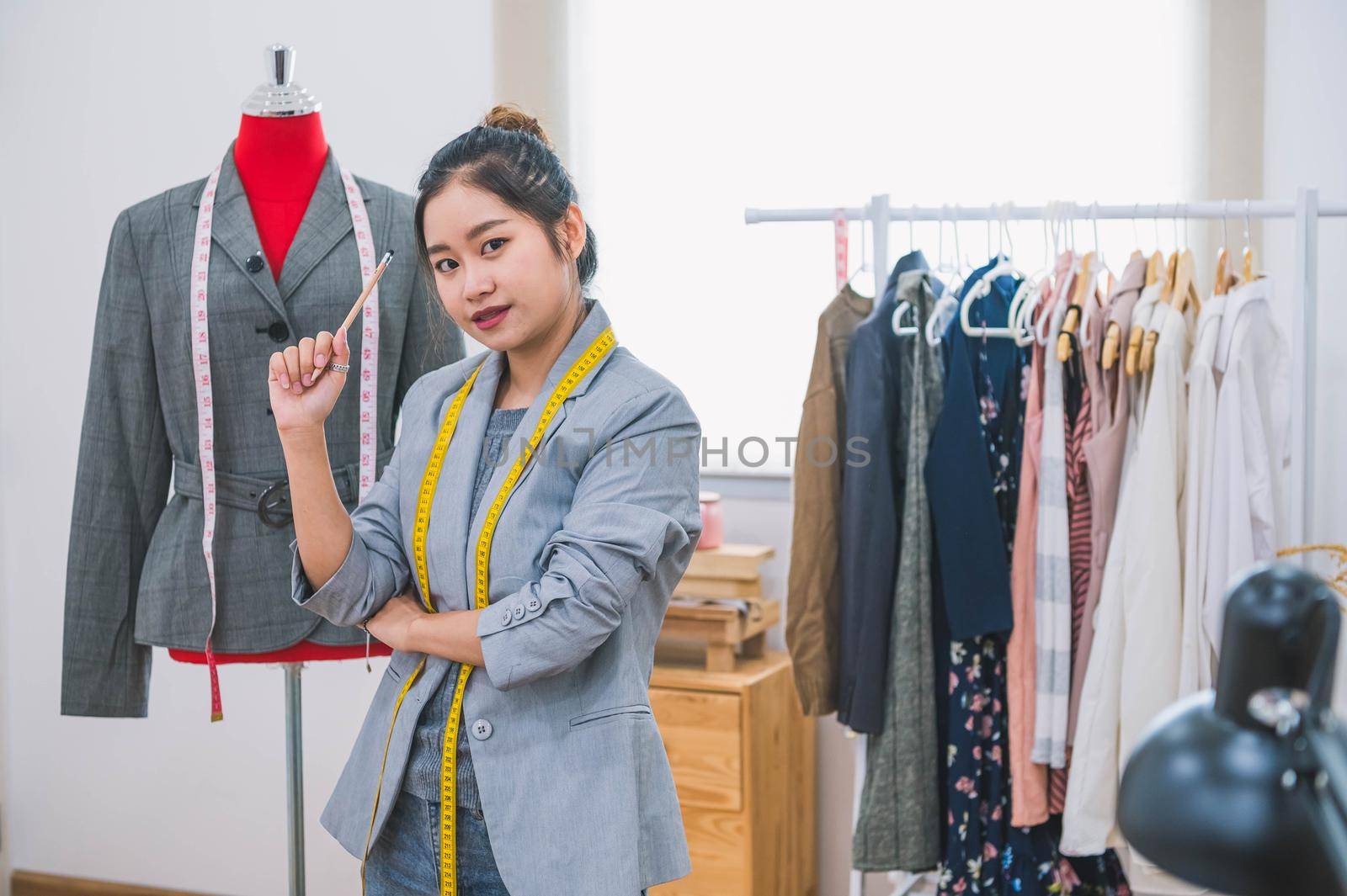 Fashion designer stylist in business owner workshop. Tailor and sewing concept. Portrait of happy casual trendy fashion designer businesswoman in studio looking camera. Business job and occupation