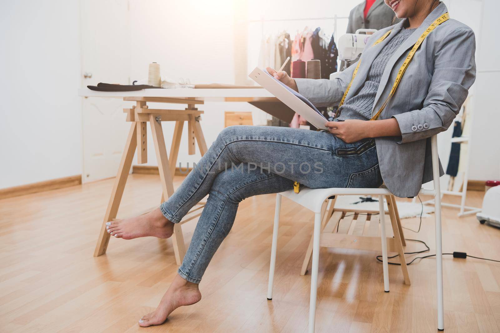 Attractive Asian female fashion designer working in home office workshop. Stylish fashionista woman creating new cloth design collection. Tailor and sewing. People lifestyle and occupation concept