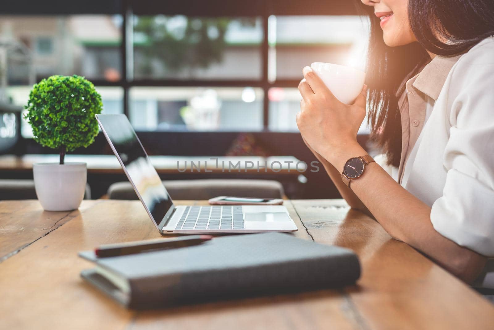 Asian working woman using laptop and drinking coffee in cafe. People and lifestyles concept. Technology and business theme. Freelance and occupation theme. Workaholic in overnight concept.