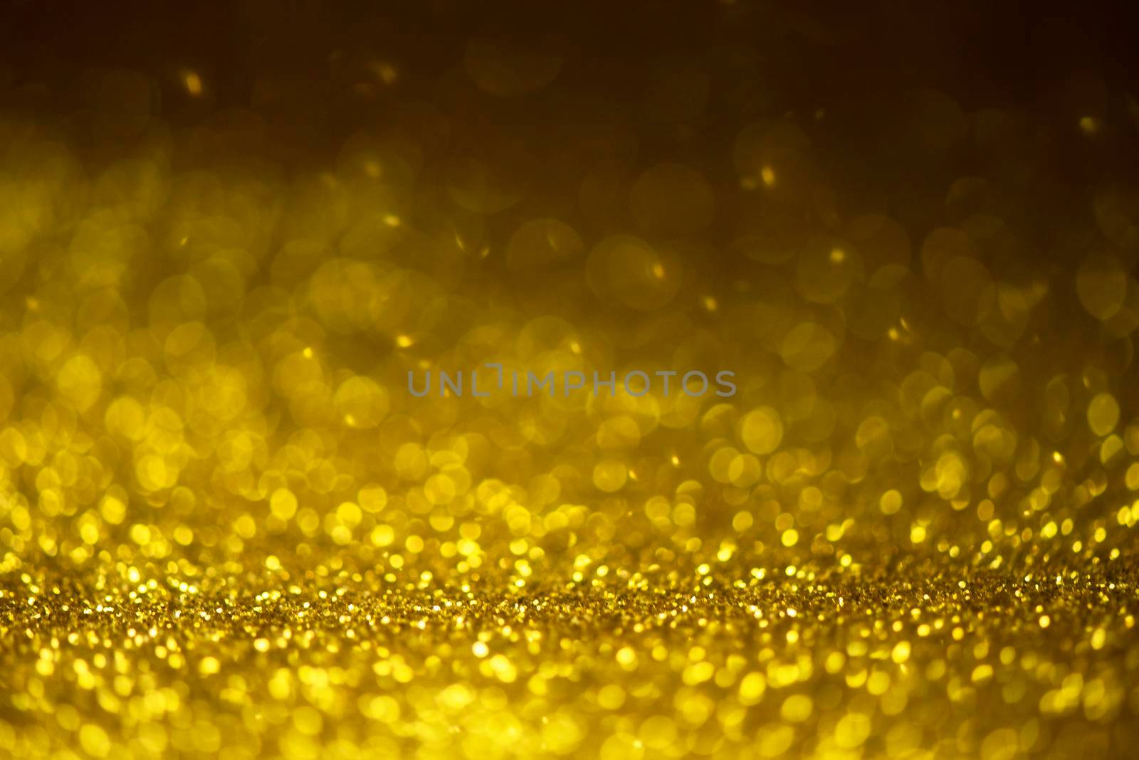 Gold glitter sparkle lights background. Defocused glitter abstract twinkly light and shiny stars. Christmas and New year party concept background. Closeup stardust. 