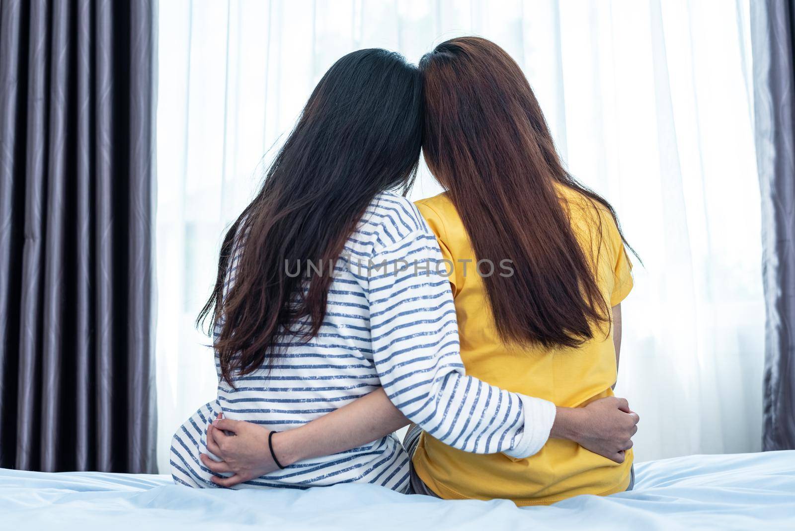 Back view of Asian beauty embracing together by a girl friend. People and Lifestyle concept. Relationship and Friendship theme. Lesbian and LGBT pride theme.