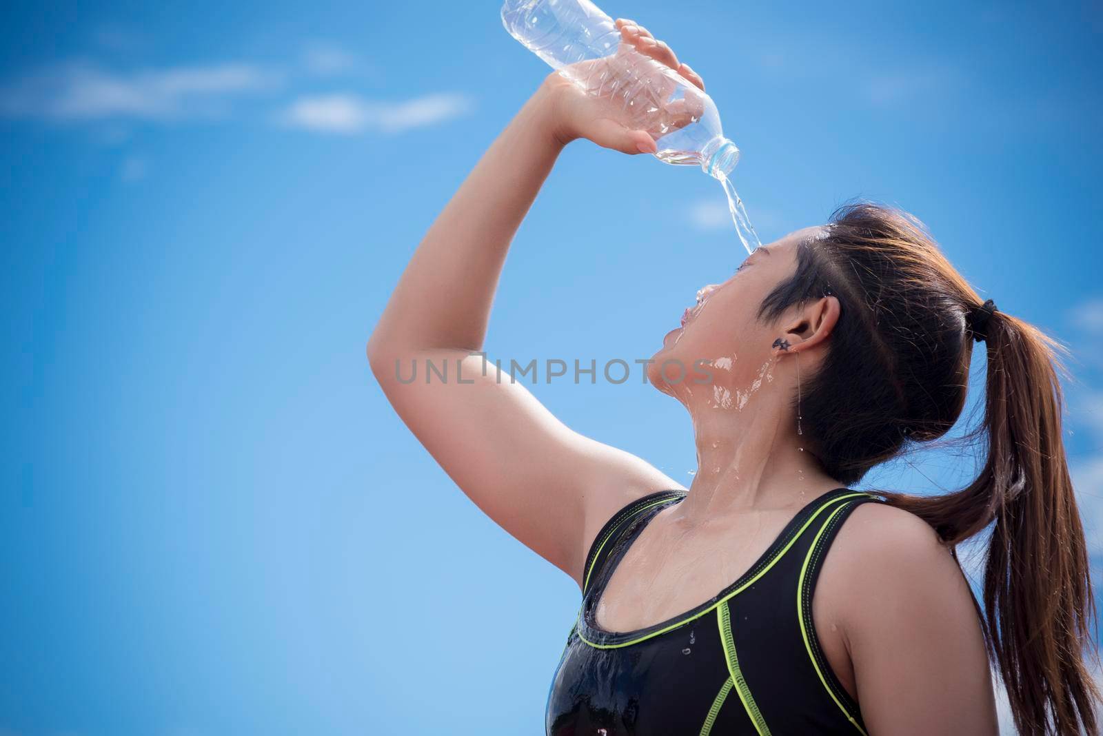 Sport girl pouring water on her face when rest or take a break time, Relax and Sport concept