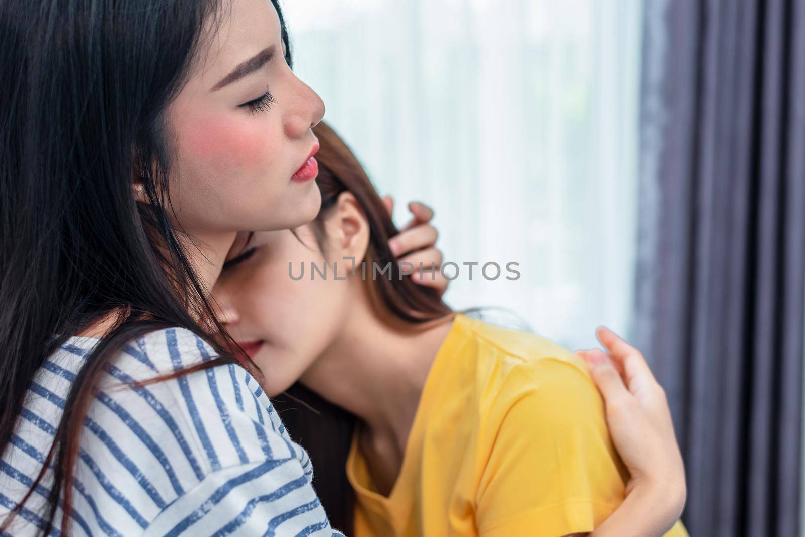 Close up of two Asian Lesbian women embracing together in bedroom. Couple people and Beauty concept. Happy lifestyles and home sweet home theme. Embracing of homosexual. Love scene making of female
