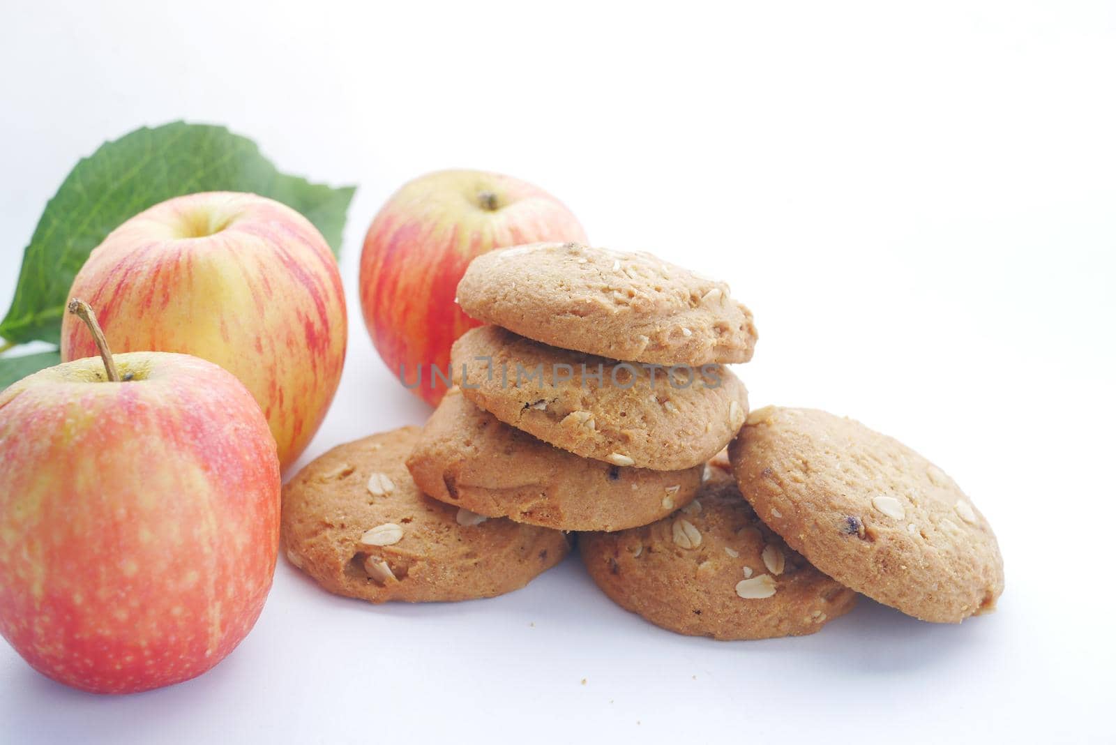 stack of whole meal cookies and apples on white background by towfiq007