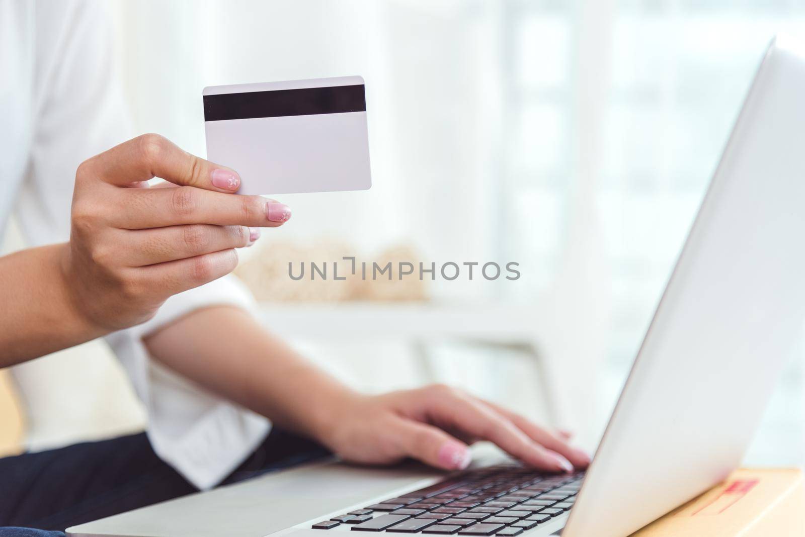 Woman hands holding credit card for online shopping or ordering product from internet when using laptop. Business and Payment concept. E-commerce and internet security concept. Home office and relax