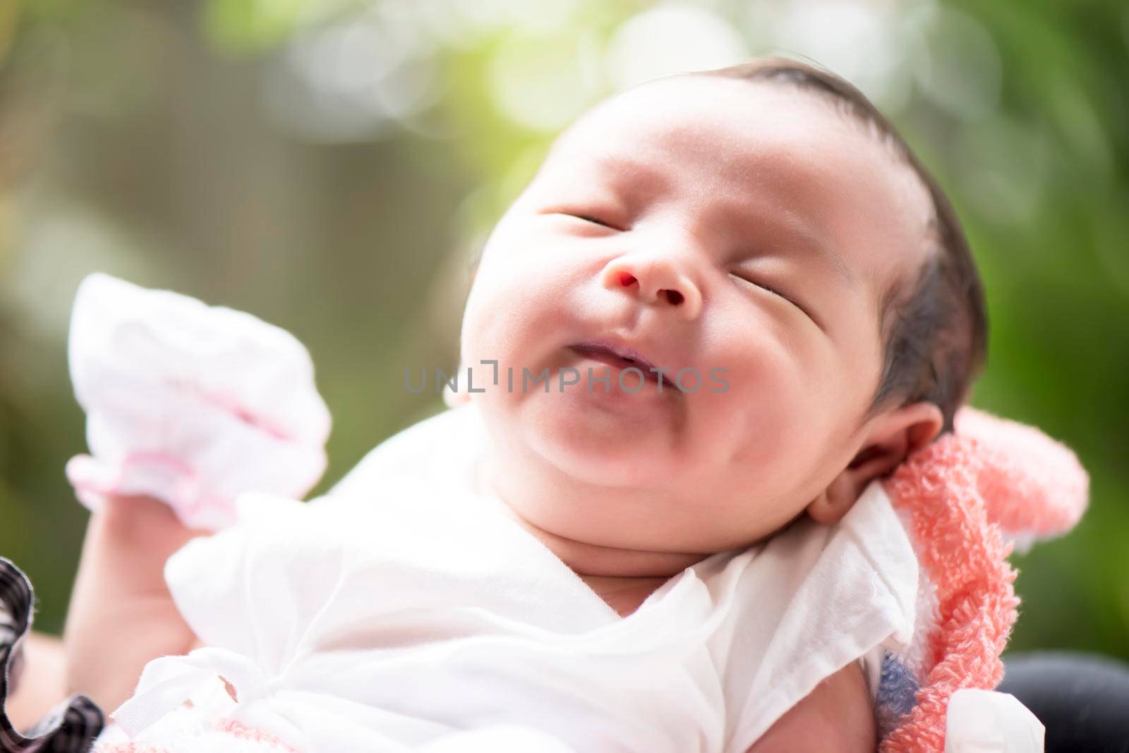 Newborn baby smiling in mother's hands, selective focus in her eyes, Family concept