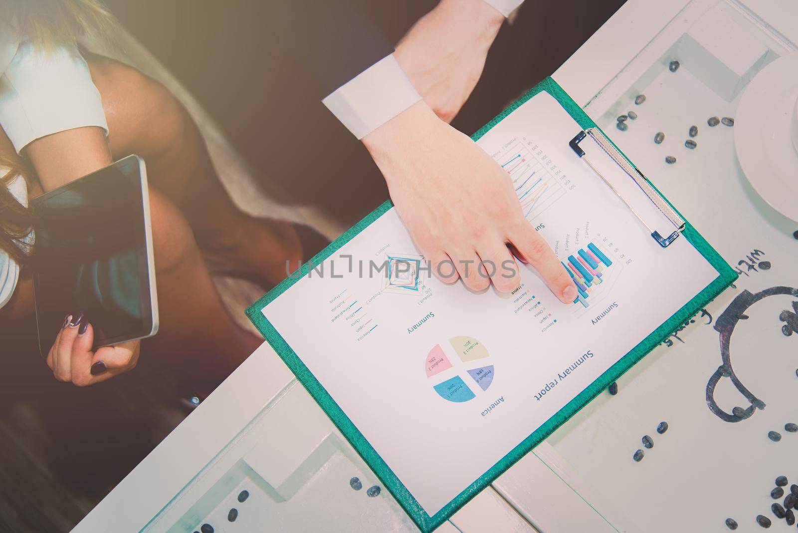 Business manager pointing to summary report and analyze graph plans with team coworker for plan to achieve marketing target, Meeting and teamwork concept. Soft tone pinterest, instragram like process
