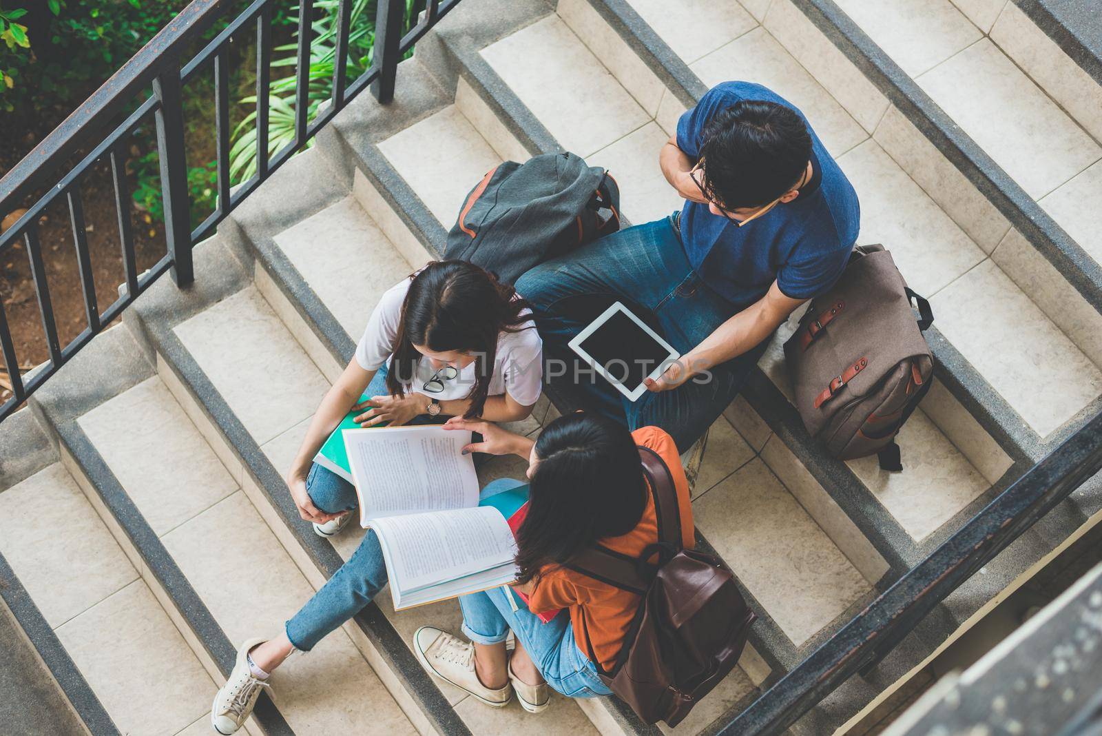 Group of Asian college student using tablet and mobile phone outside classroom. Happiness and Education learning concept. Back to school concept. Teen and people theme. Outdoors and Technology theme.