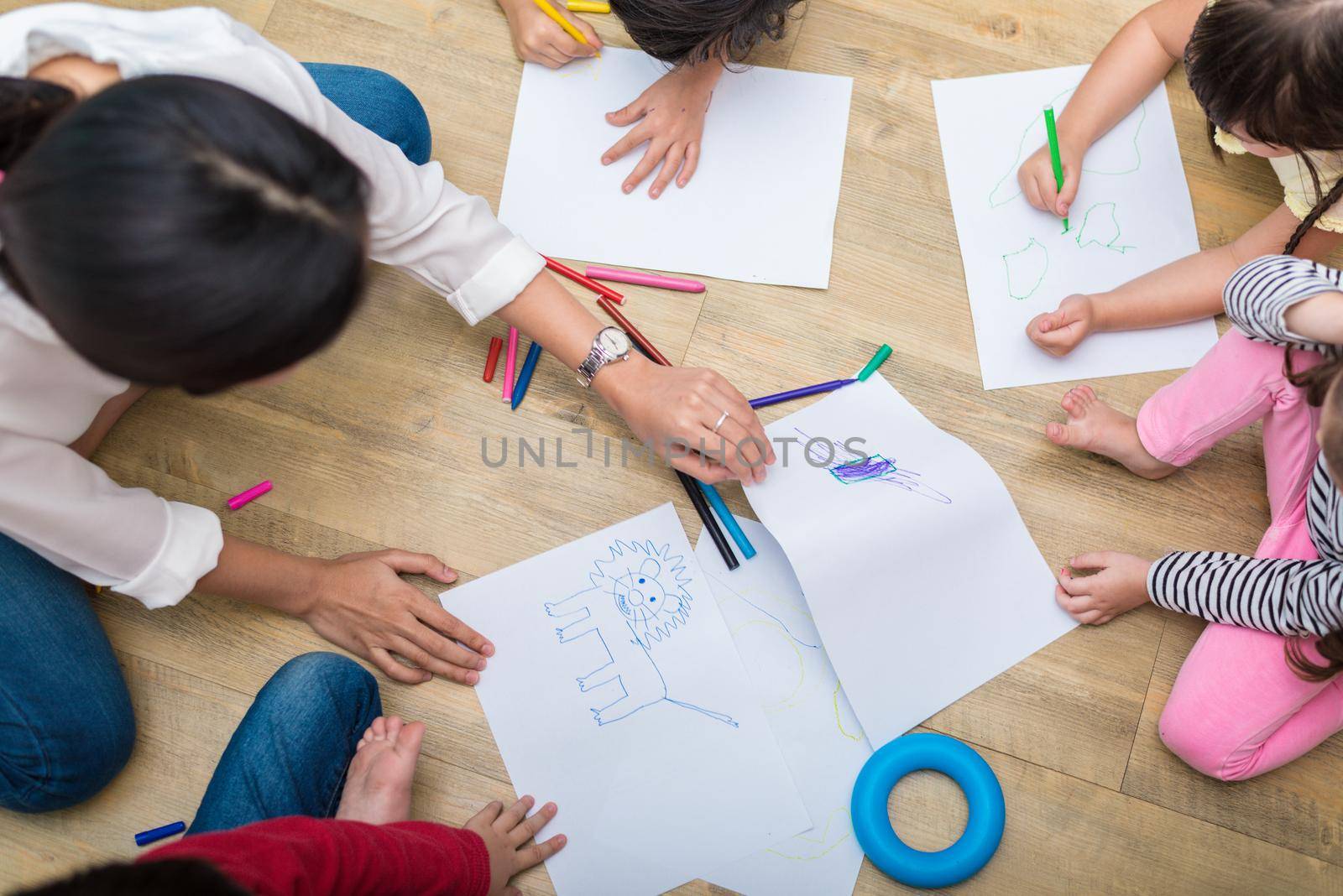 Group of preschool student and teacher drawing on paper in art class. Back to school and Education concept. People and lifestyles theme.  classroom in nursery by MiniStocker