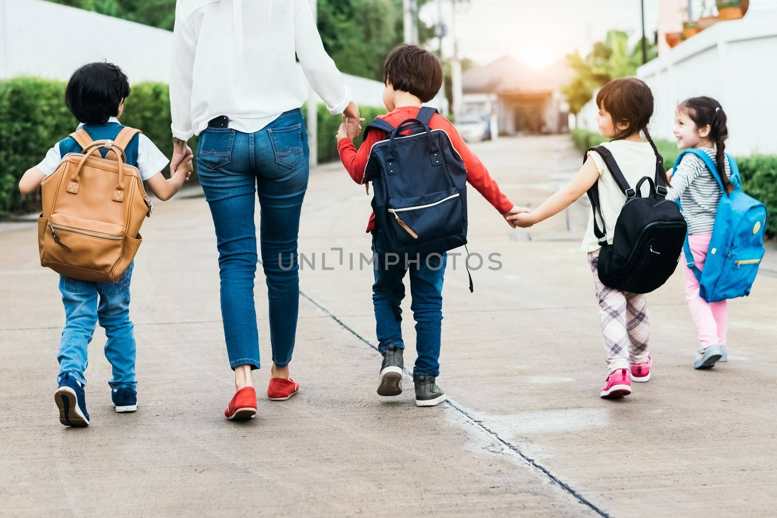 Back to school students mother group going school together. Parent send little boy and girl for first class semester term with schoolbag or satchel together. Collaborative learning and empathy daycare