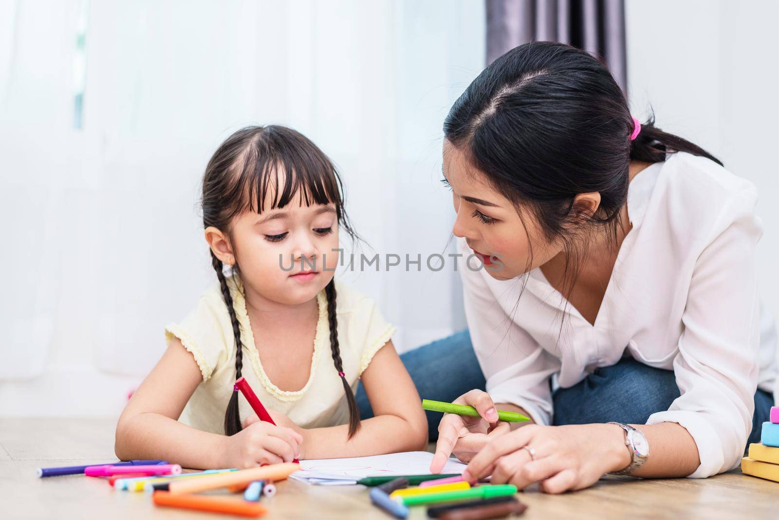 Mom teaching her daughter to drawing in art class. Back to school and Education concept. Children and kids theme. Home sweet home theme.