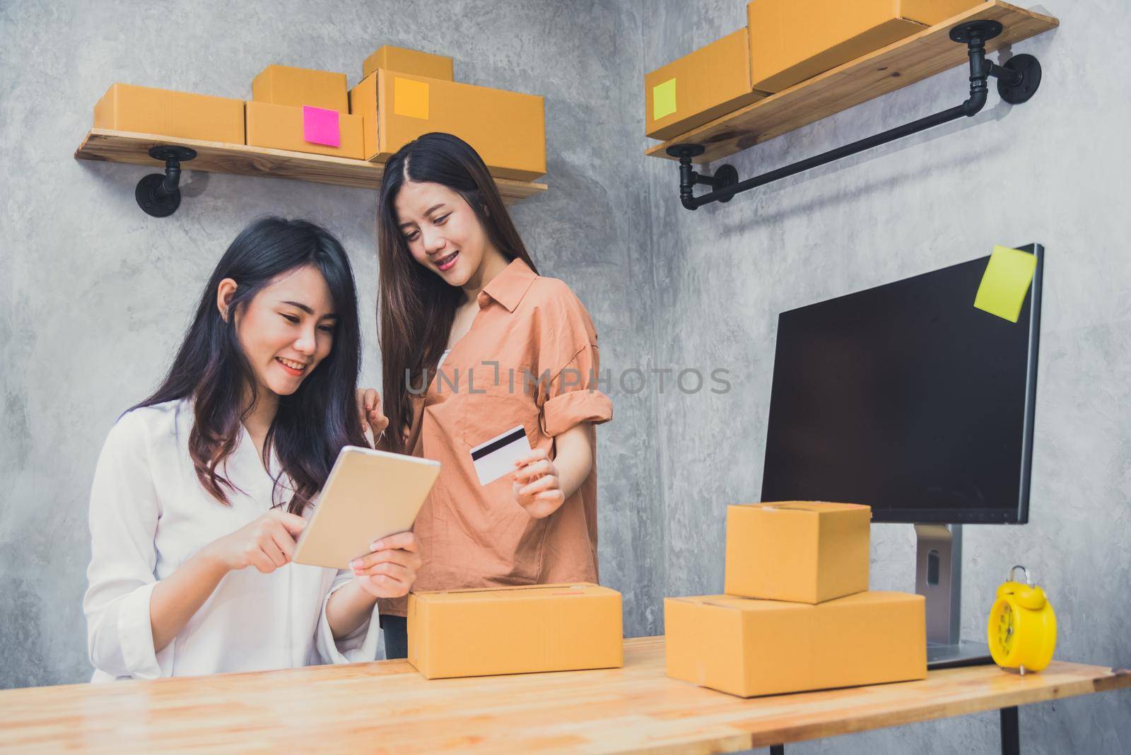 Two young Asian people startup small business entrepreneur SME distribution warehouse with parcel mail box. small  owner home office. Online marketing and product packaging and delivery service