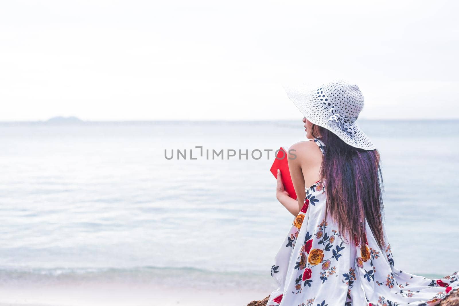 Asian woman waiting for love or someone make her happy. Lonely and Beauty concept. Back view scene of girl. Ocean and sea theme. Copy space in left side. Woman day and soulmate theme.