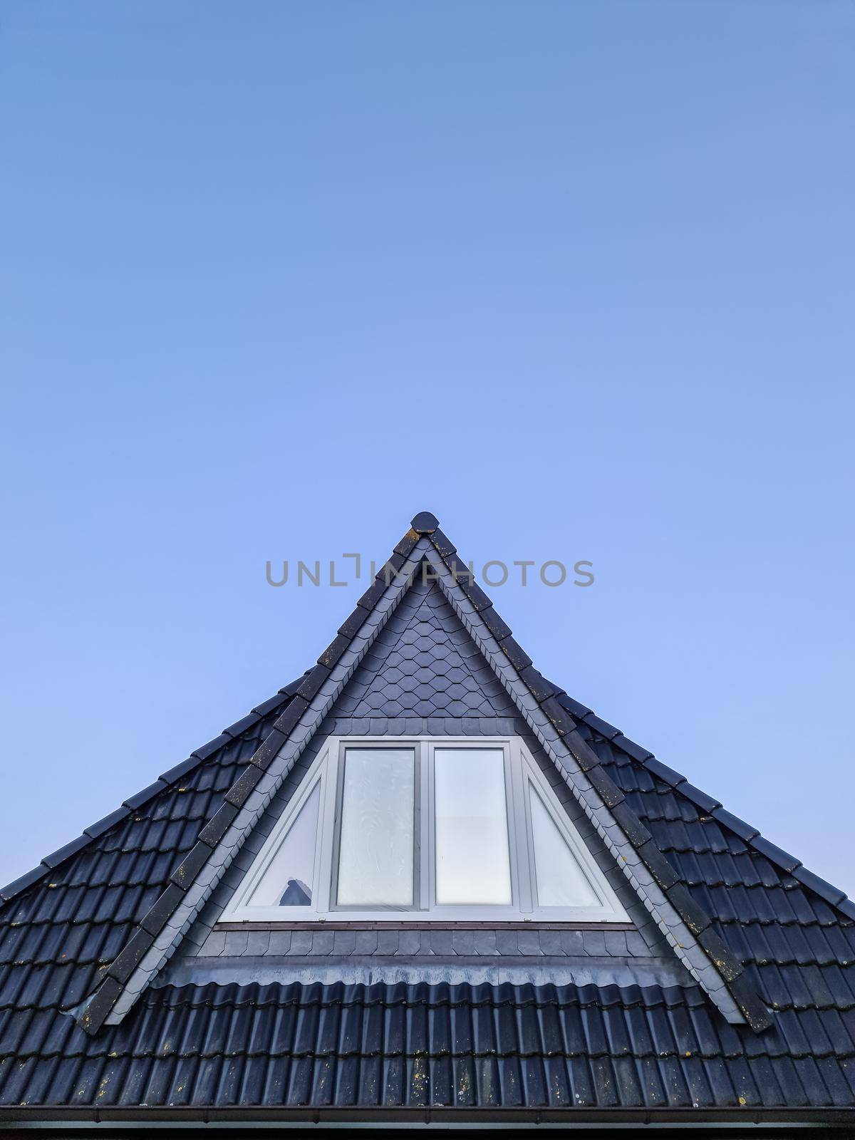 Open roof window in velux style with black roof tiles