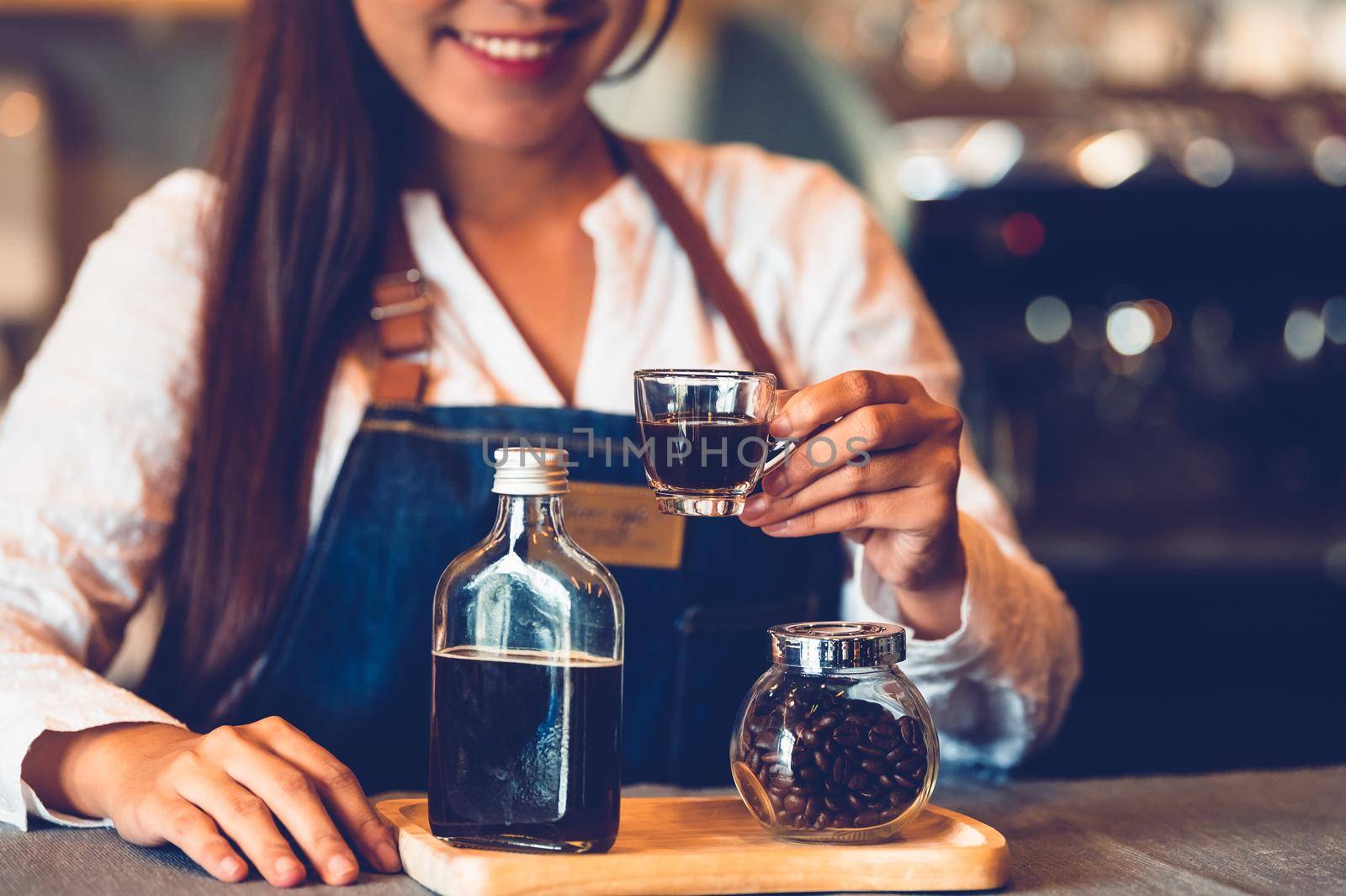 Closeup of coffee cup with beautiful Asian woman barista background for making coffee to serving to customer. Job and occupation. Food and drink beverage. Coffee shop and Cafe. Business and restaurant