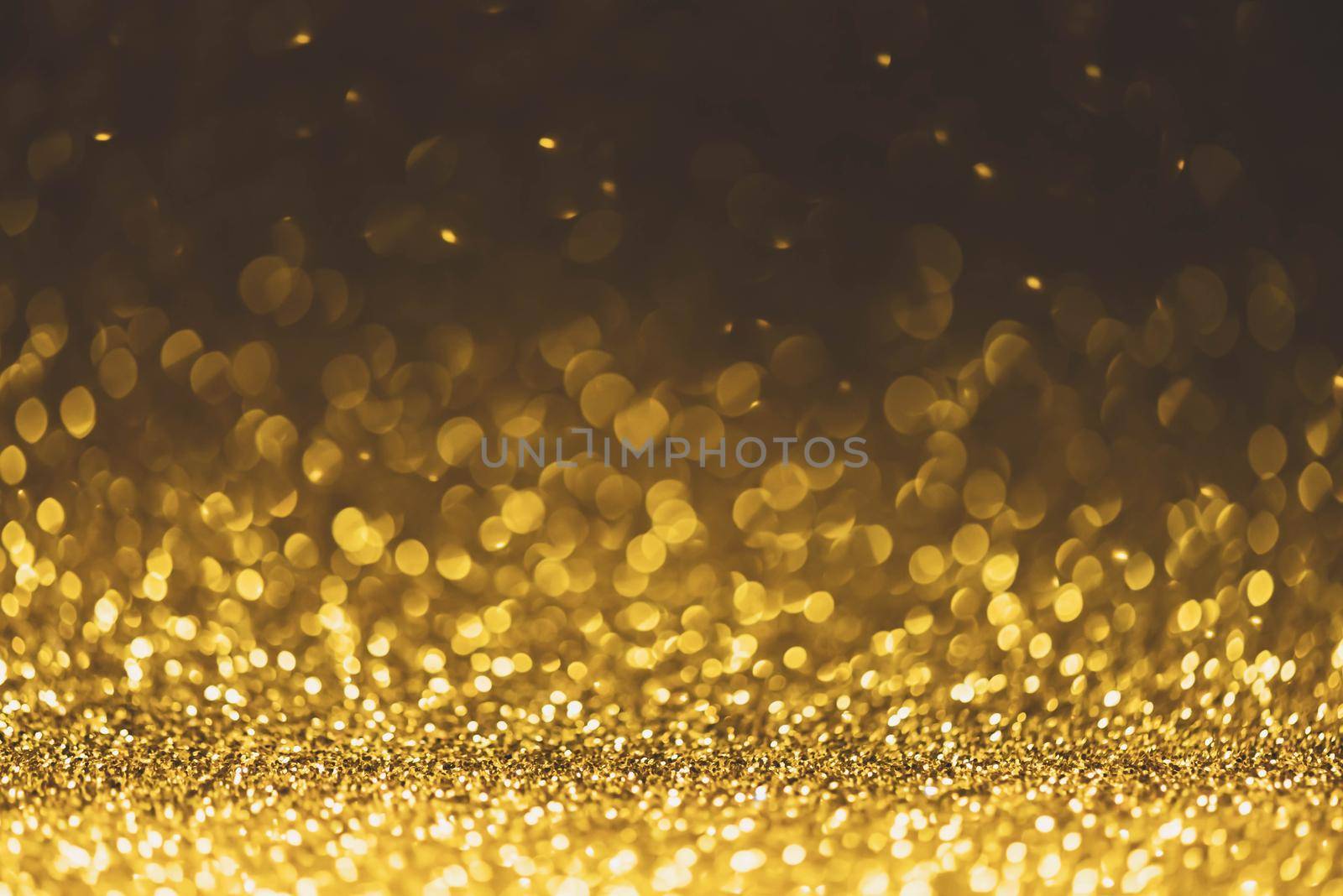 Gold glitter sparkle lights background. Defocused glitter abstract twinkly light and shiny stars. Christmas and New year party concept background. Closeup stardust. 