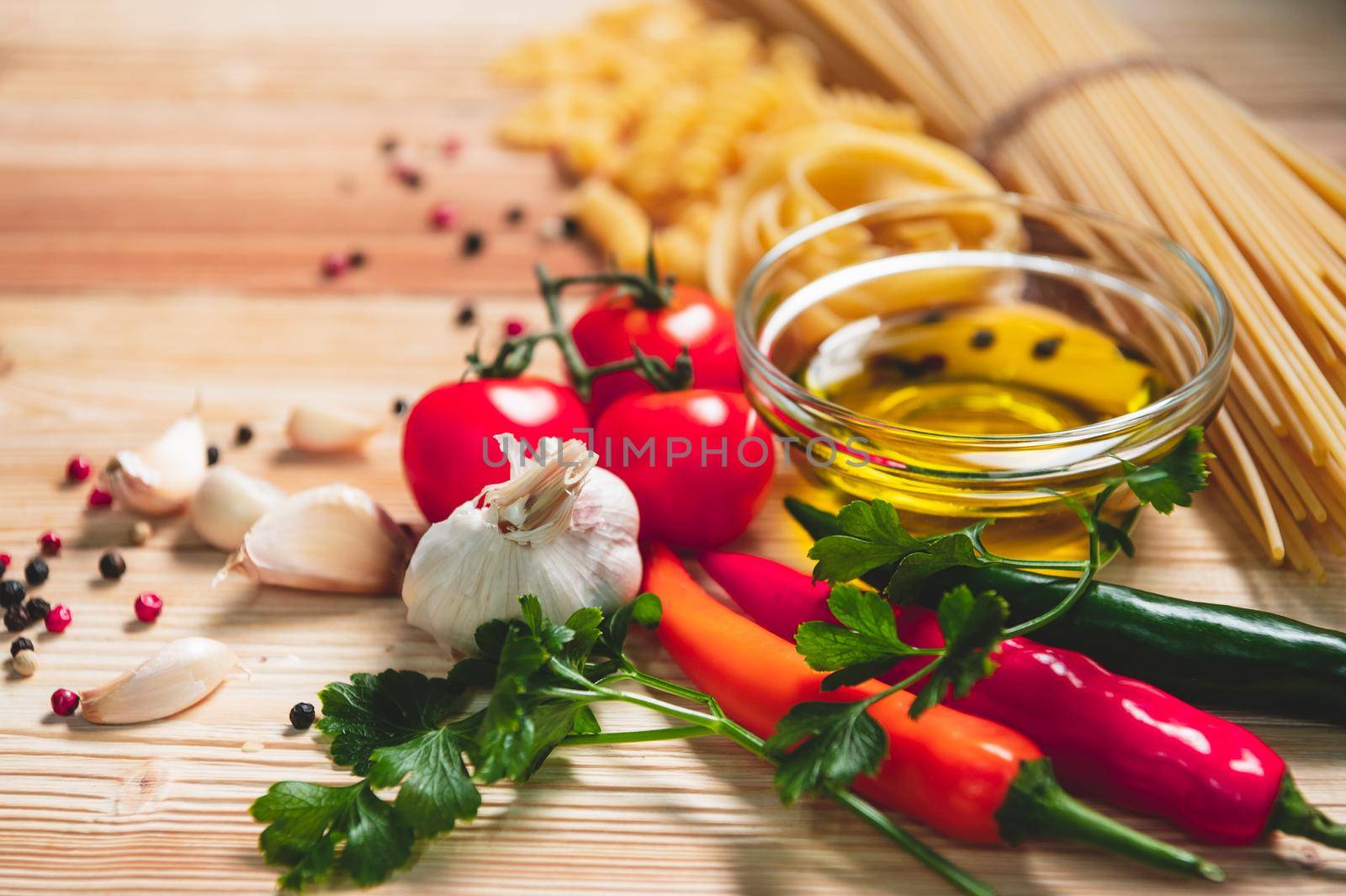 Tasty appetizing italian spaghetti pasta ingredients for kitchen cuisine with tomato, cheese parmesan, olive oil, fettuccine and basil on wooden brown table. Food Italian recipe homemade. Top view