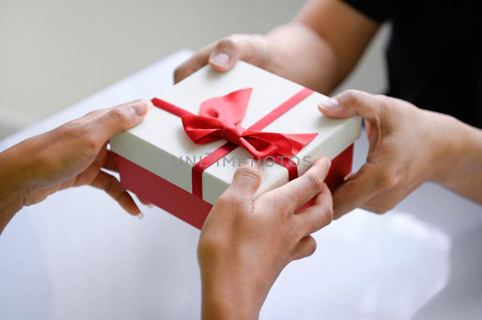 Closeup of hands giving gift box in Christmas day and new year festival to each other. Holiday and event. Surprising giftbox in dating on end year party. People lifestyle and object concept.