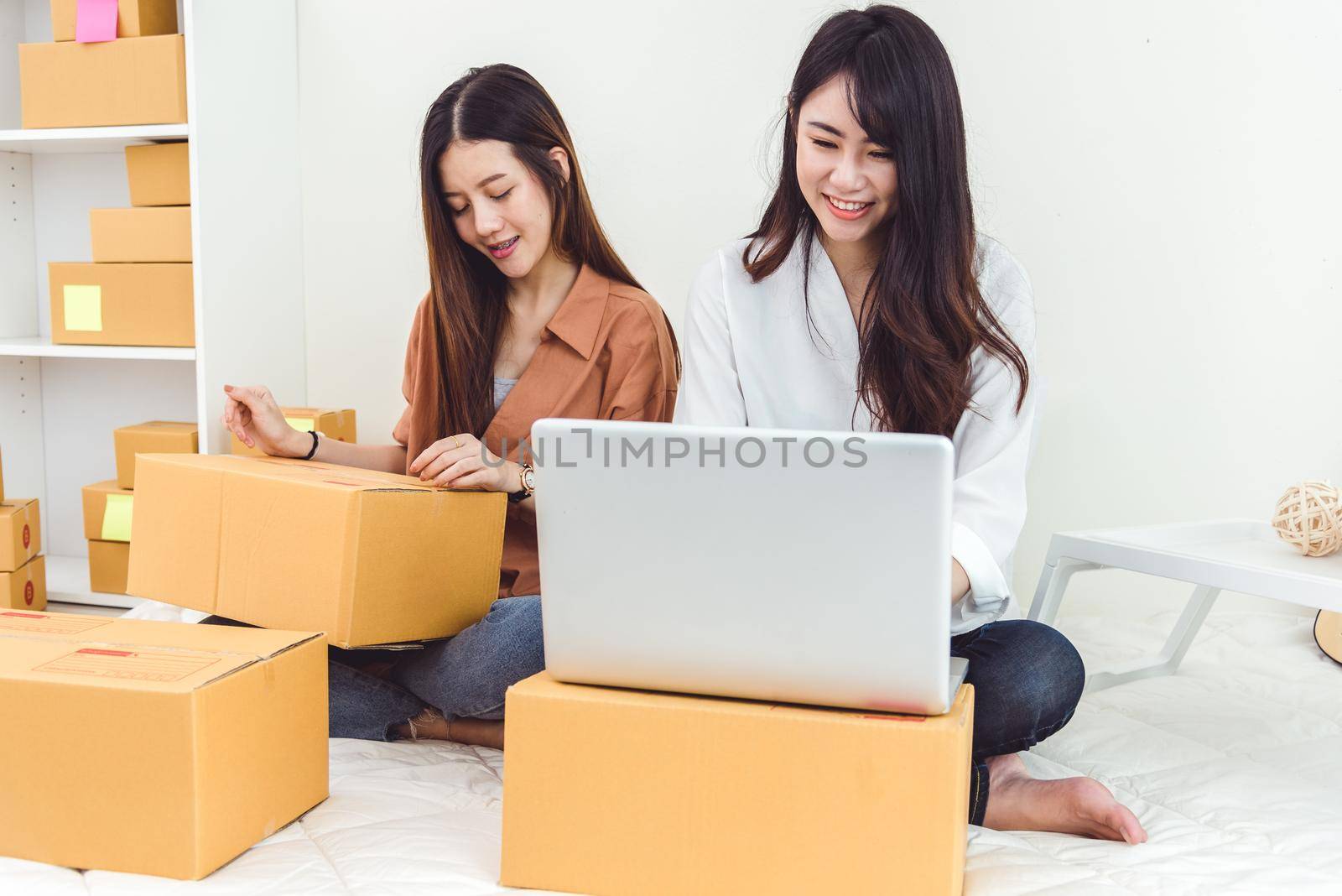 Young Asian woman startup small business entrepreneur SME distribution warehouse with parcel mail box. Owner home office concept. Online marketing and product packaging and delivery service.