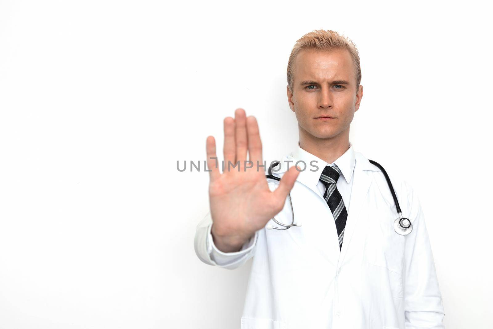 Doctor with stethoscope show off "stop" or "not allowed" sign by his hand on the white background. Medical and Healthcare concept. Hospital theme