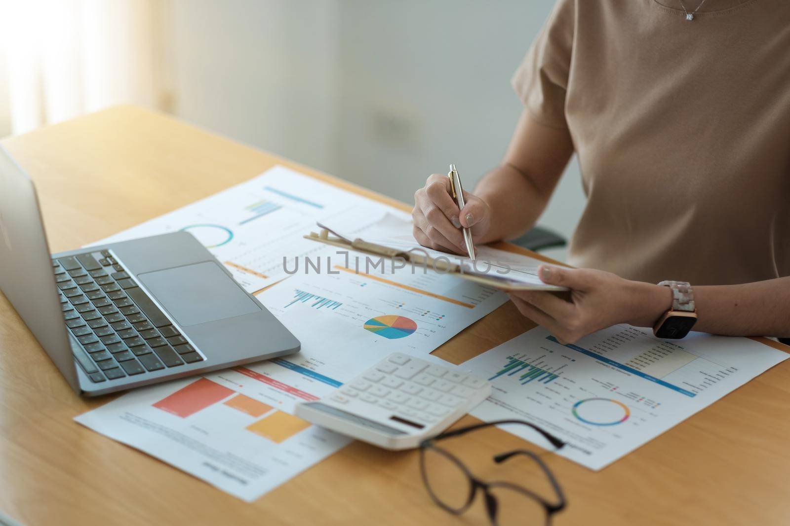 Cropped shot of accountants work analyzing financial reports on a laptop at his office, business analytics concept by nateemee