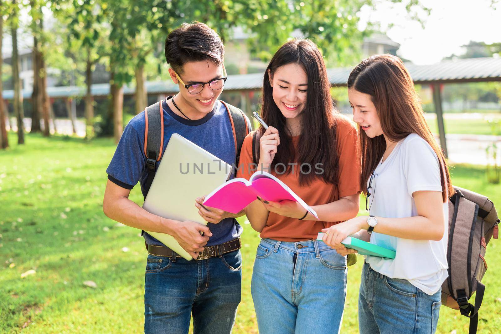 Three Asian young campus students enjoy tutoring and reading books together. Friendship and Education concept. Campus school and university theme. Happiness and funny of learning in college