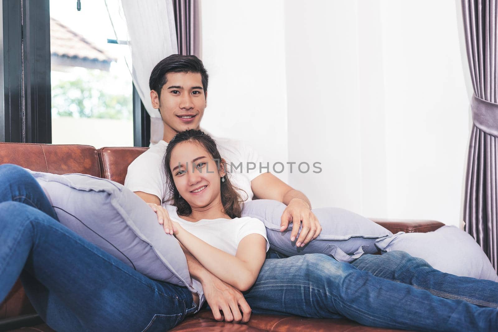 Sweet free time together. Happy beautiful lovers spending weekend together on couch or sofa indoors at home, Relaxing and Enjoying on couple concept in holidays