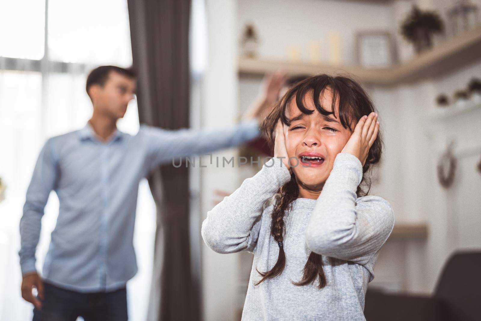 Little girl crying because of her parents quarreling. Girl abused with mother and father shouting and conflict angry background in home. Family dramatic scene, Family social issues problem concept.