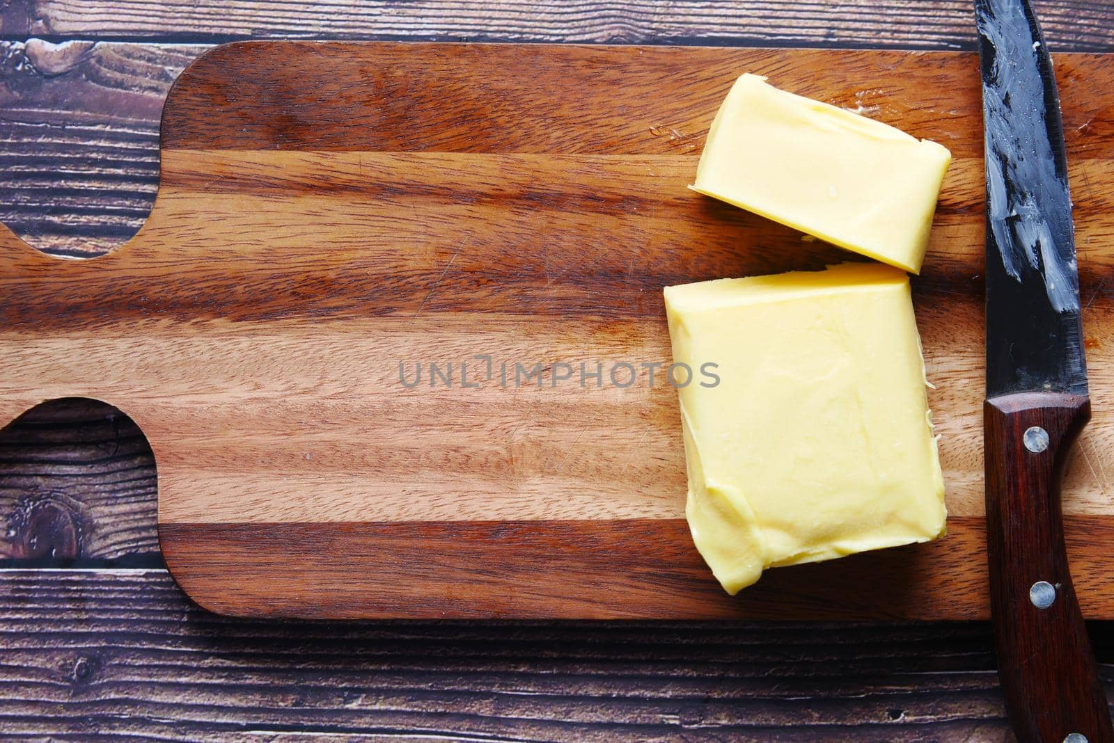 slice of butter on chopping board top down .