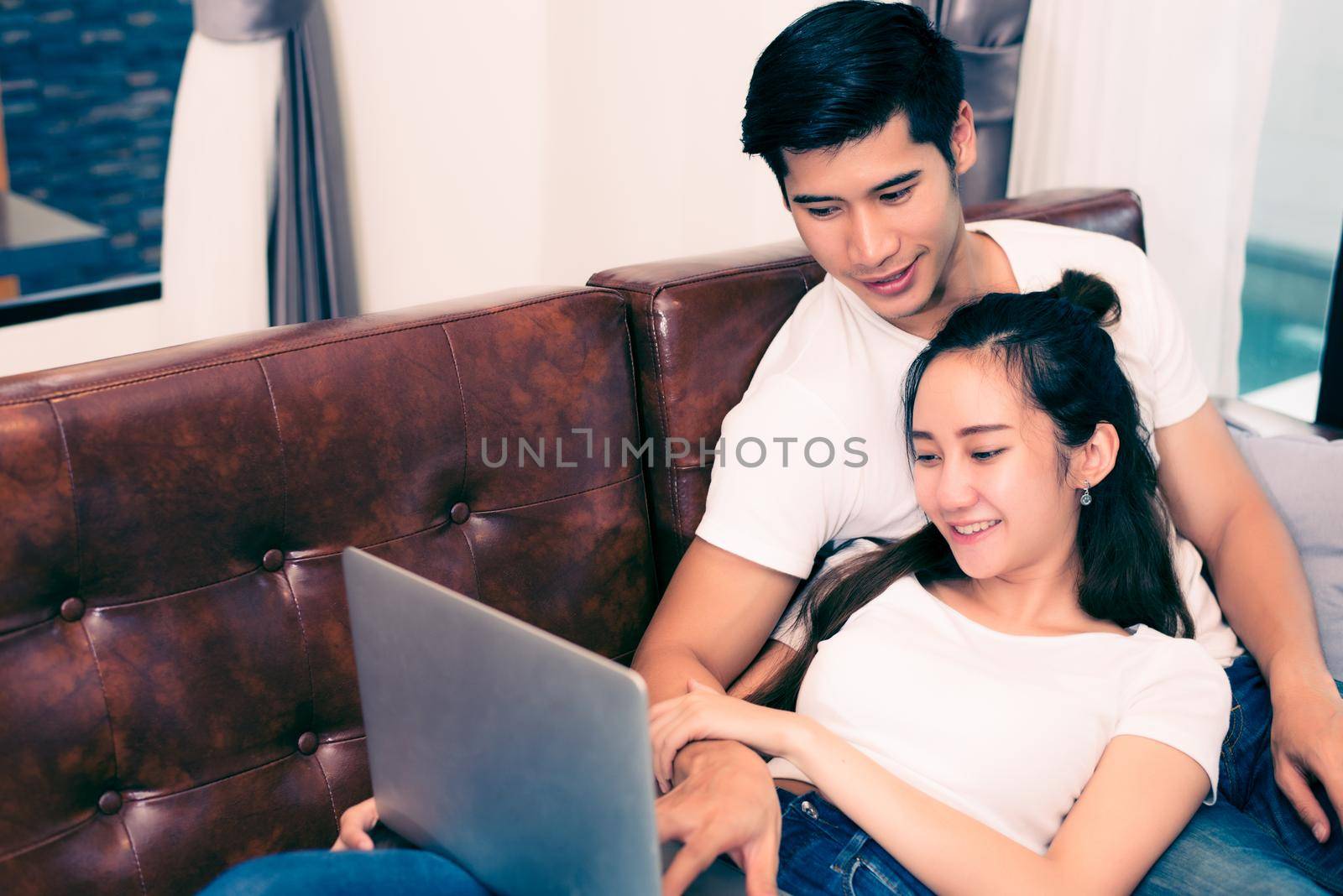 Asian young couples using laptop. Lovers and Couples concept. Honeymoon and Wedding theme. Interior and Dating theme.