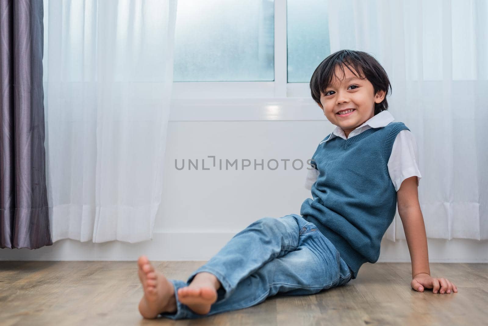 Happy boy sitting and smiling in bedroom. Lifestyles and people concept. Portrait and Happiness life concept. Home sweet home theme.