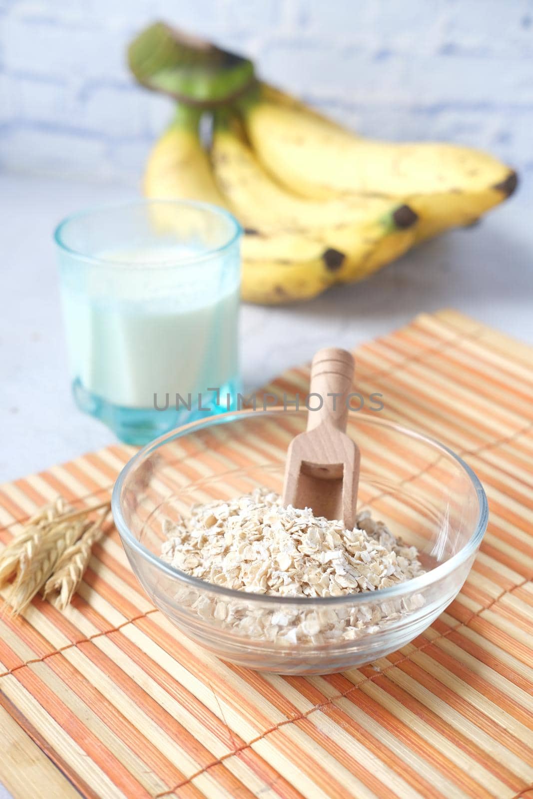 oats flakes , glass of milk and banana on table ,