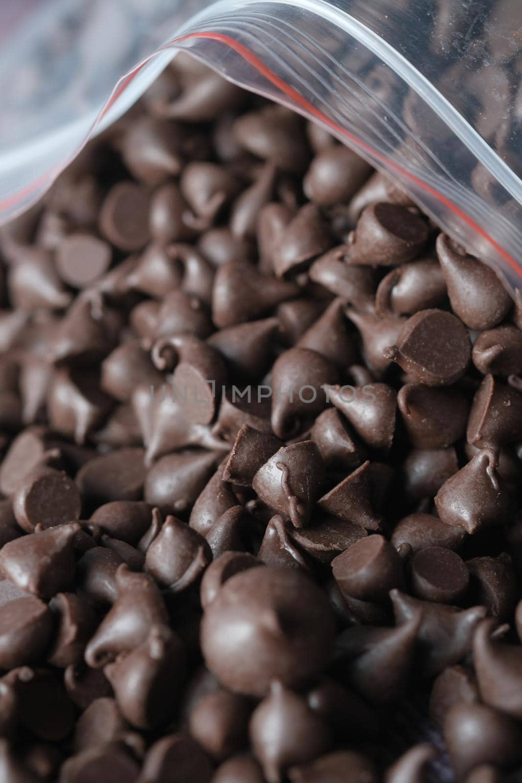 Chocolate chips spilling from a plastic packet, by towfiq007