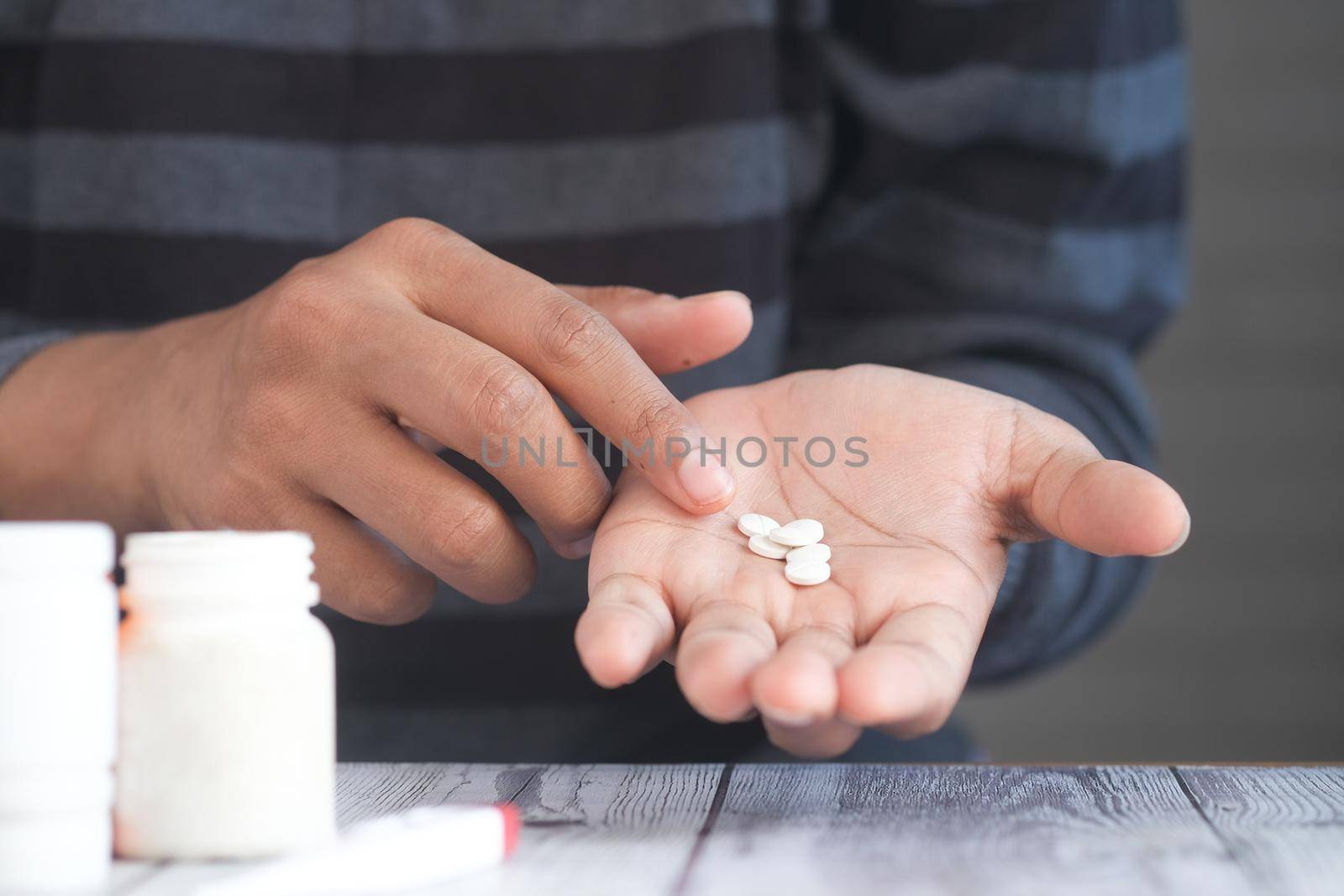 man's hand with medicine spilled out of the pill container by towfiq007