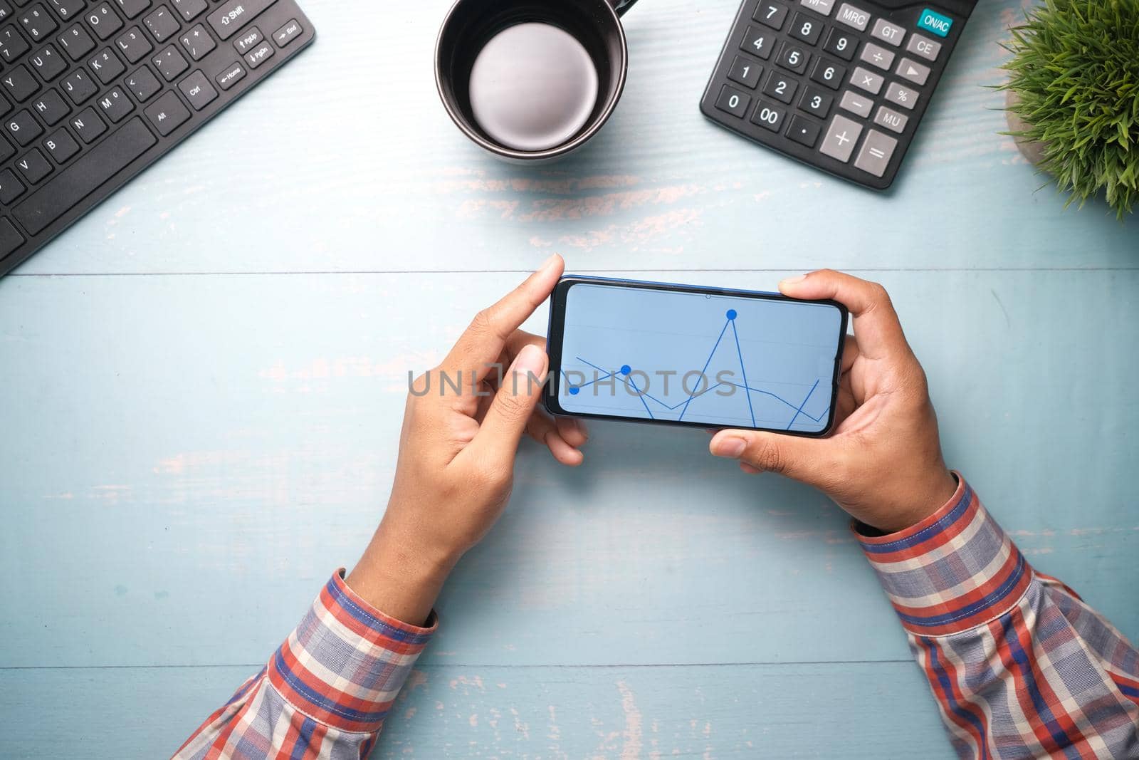 young man analyzing stock chart on smart phone .