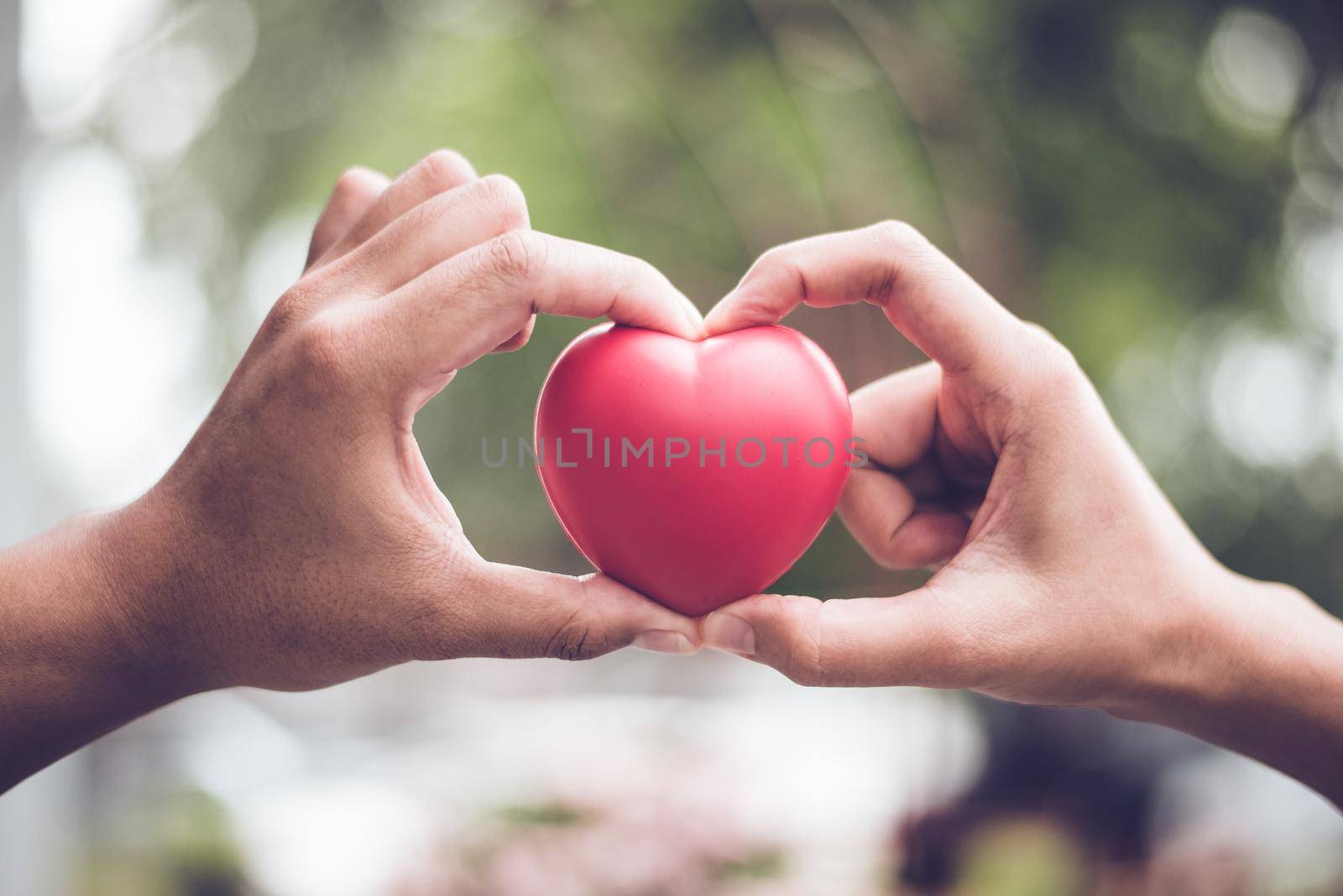 Couple in love making heart symbol shape with finger and hands togetherness. Valentines day concept. Romantic travel trip and wedding honeymoon theme. Outdoors nature background