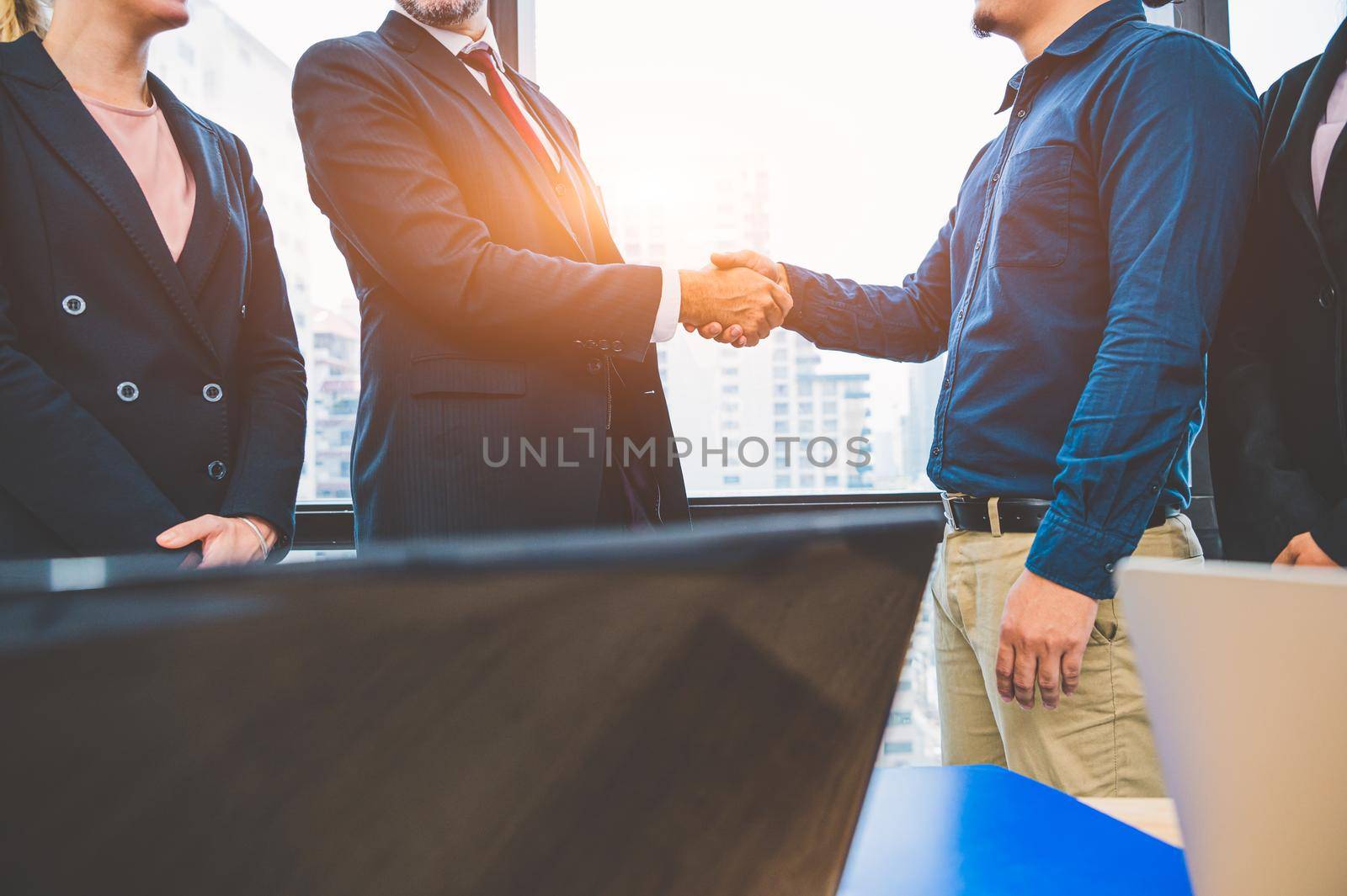Business partnership meeting handshaking concept. Businessmen doing handshake. Successful business people contract handshaking after finished good dealing with skyscraper window building background.