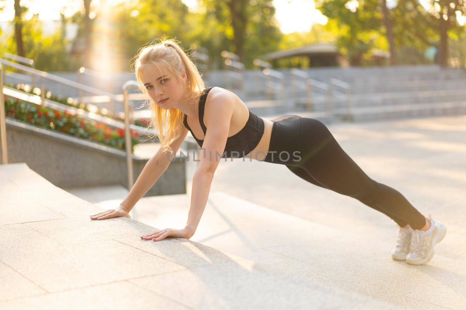 Sport and Fitness Fit Young Adult Woman Doing Plank Exercise Outdoor Urban Environment. Sunlight Summer Park Caucasian Ahlrtic Female Morning Workout Training Exercises Endurance Abs Muscle