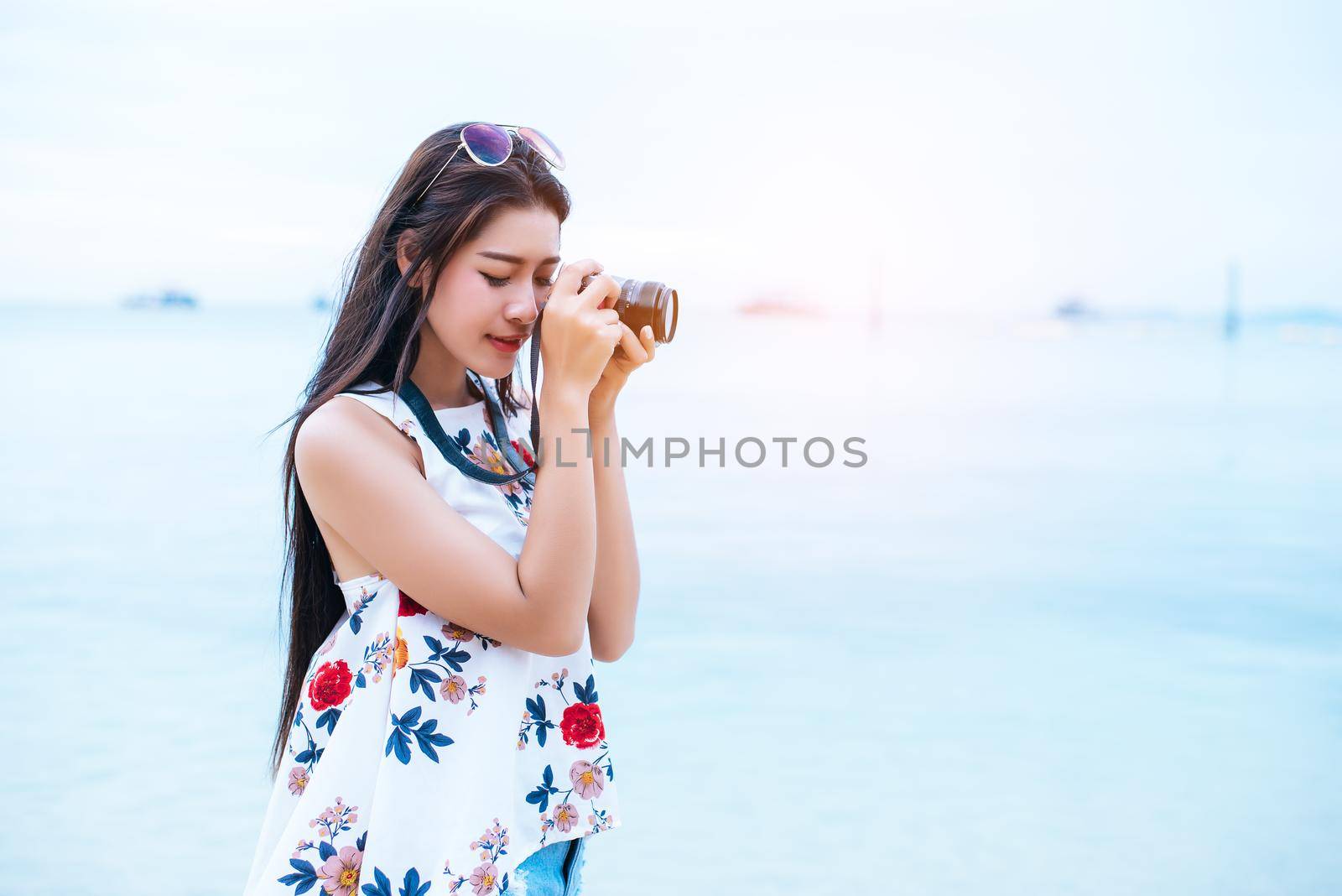 Asian woman enjoy take photo by digital camera at beach. Single and lonely woman concept. Happiness and Lifestyle concept. Beauty and Nature theme. Ocean and sea background. Technology and woman day by MiniStocker