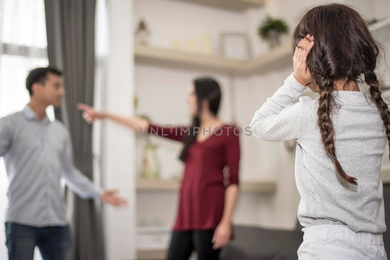 In back view, Little girl puts her hands on her ears because she does not want to hear her dad and mom quarrel. close ears, Family Dramatic scene, Parrents issues, Social and parents problem concept