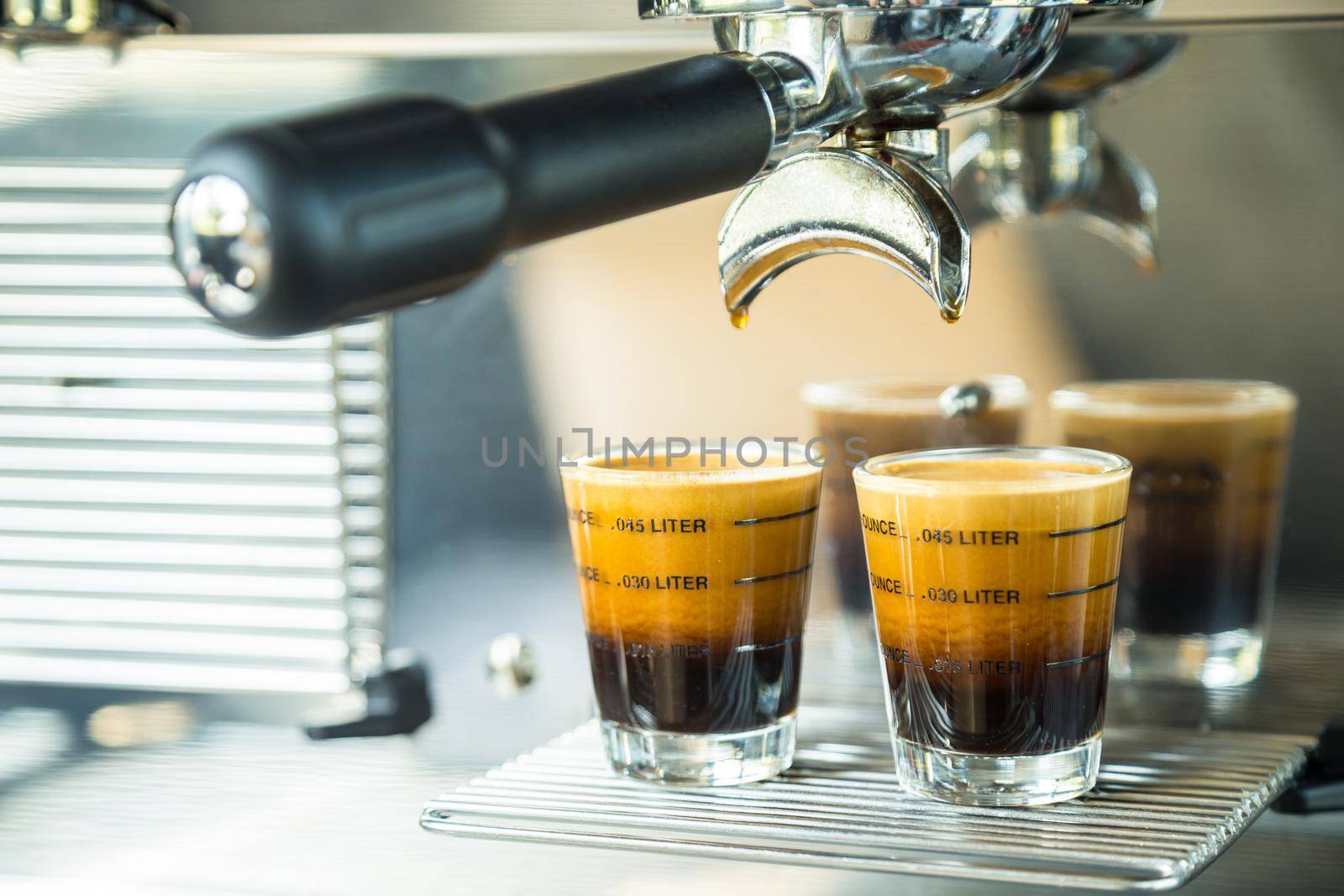 Black coffee in glass from coffee maker machine.
